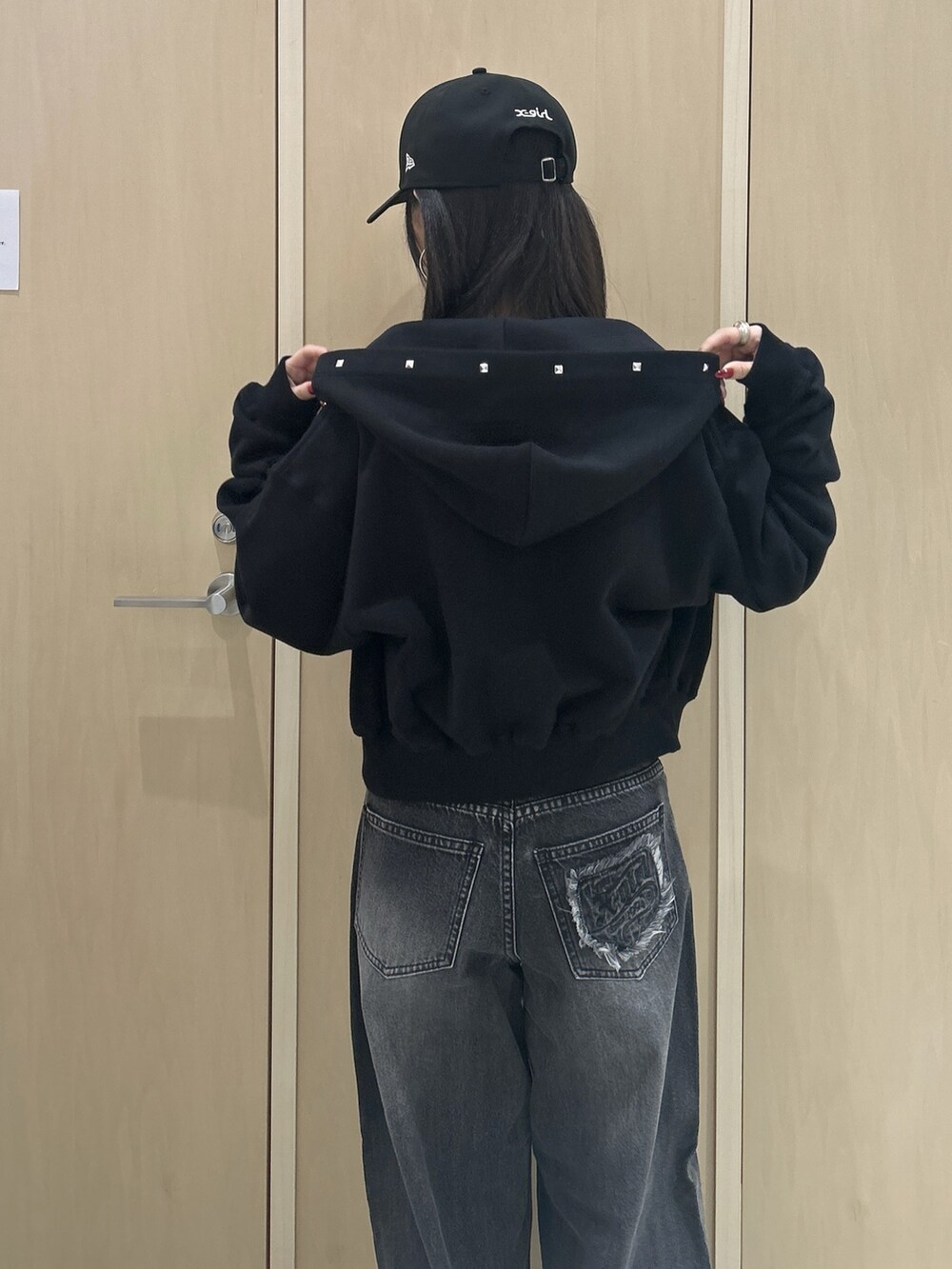 ピンク系のTシャツ/カットソー、ブラック系のパーカー、ブラック系のデニムパンツを着用したレディースの秋コーディネートの5枚目の写真