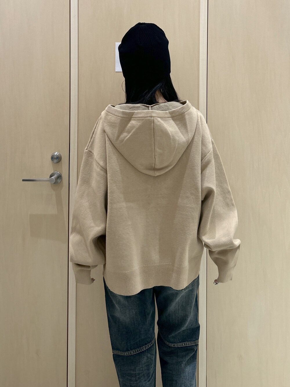 ベージュ系のニット/セーター、ブルー系のデニムパンツ、ブラック系のニットキャップ/ビーニーを着用したレディースの冬コーディネートの4枚目の写真