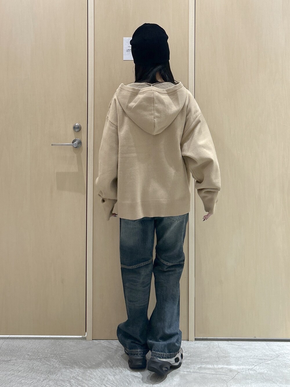 ベージュ系のニット/セーター、ブルー系のデニムパンツ、ブラック系のニットキャップ/ビーニーを着用したレディースの冬コーディネートの2枚目の写真