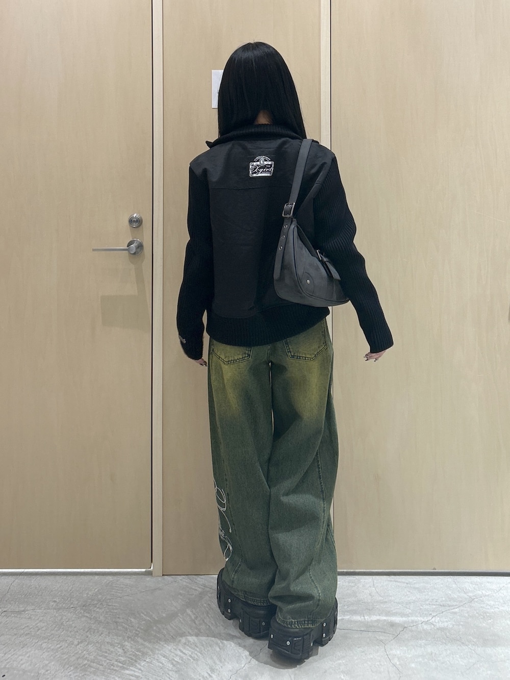 グレー系のTシャツ/カットソー、ブラック系のブルゾン、ブラック系のハンドバッグを着用したレディースの冬コーディネートの3枚目の写真