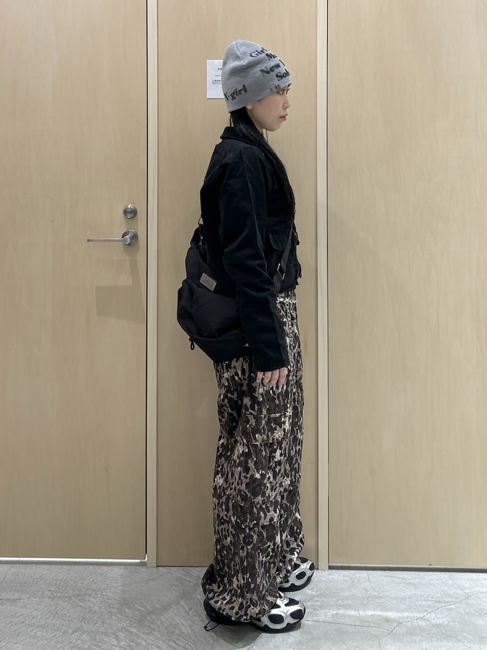 ブラック系のブルゾン、ベージュ系のカーゴパンツ、ブラック系のショルダーバッグを着用したレディースの冬コーディネートの2枚目の写真