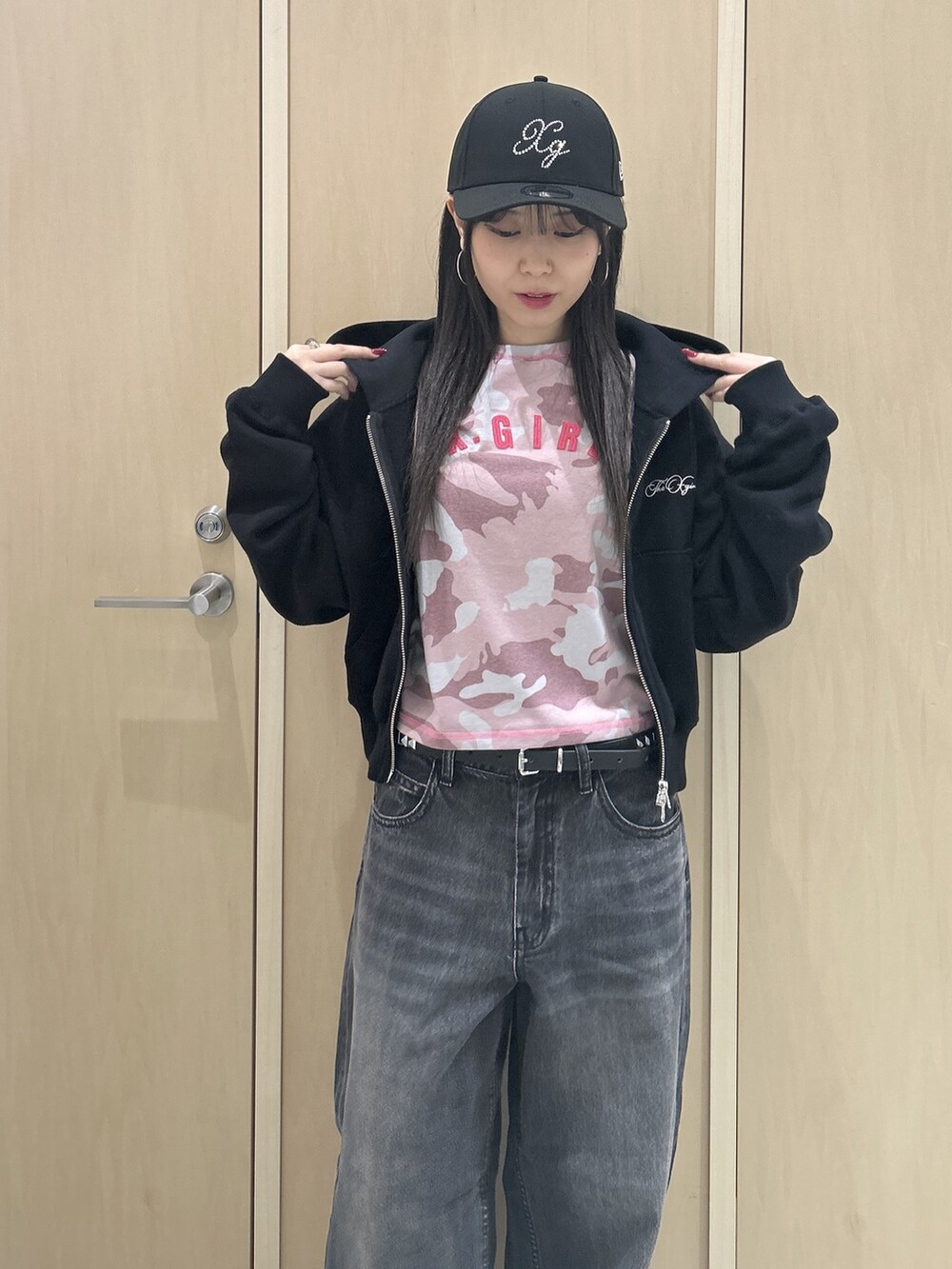 ピンク系のTシャツ/カットソー、ブラック系のパーカー、ブラック系のデニムパンツを着用したレディースの秋コーディネートの6枚目の写真