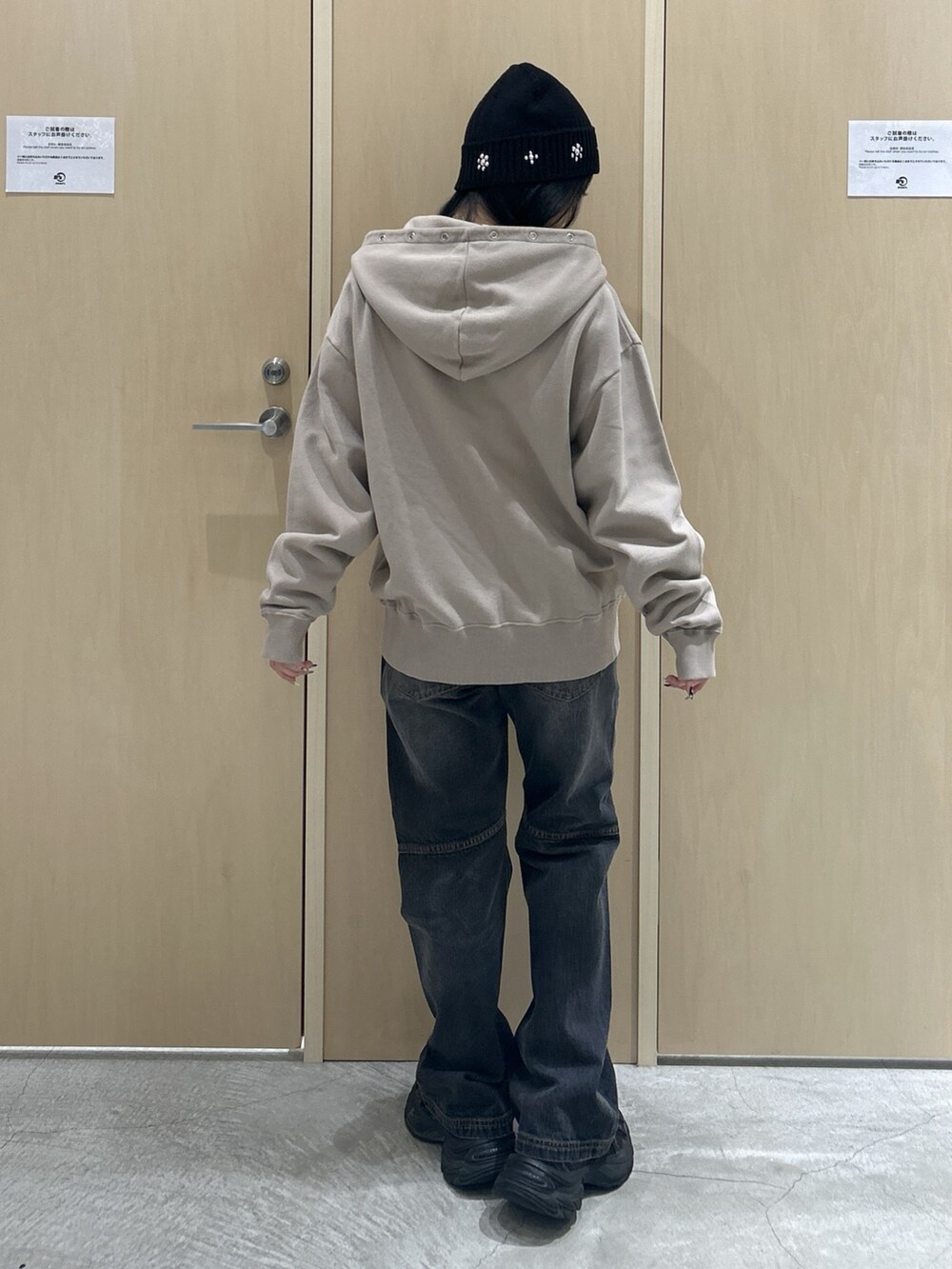 ベージュ系のパーカー、ブラック系のデニムパンツ、ブラック系のハットを着用したレディースの秋コーディネートの3枚目の写真