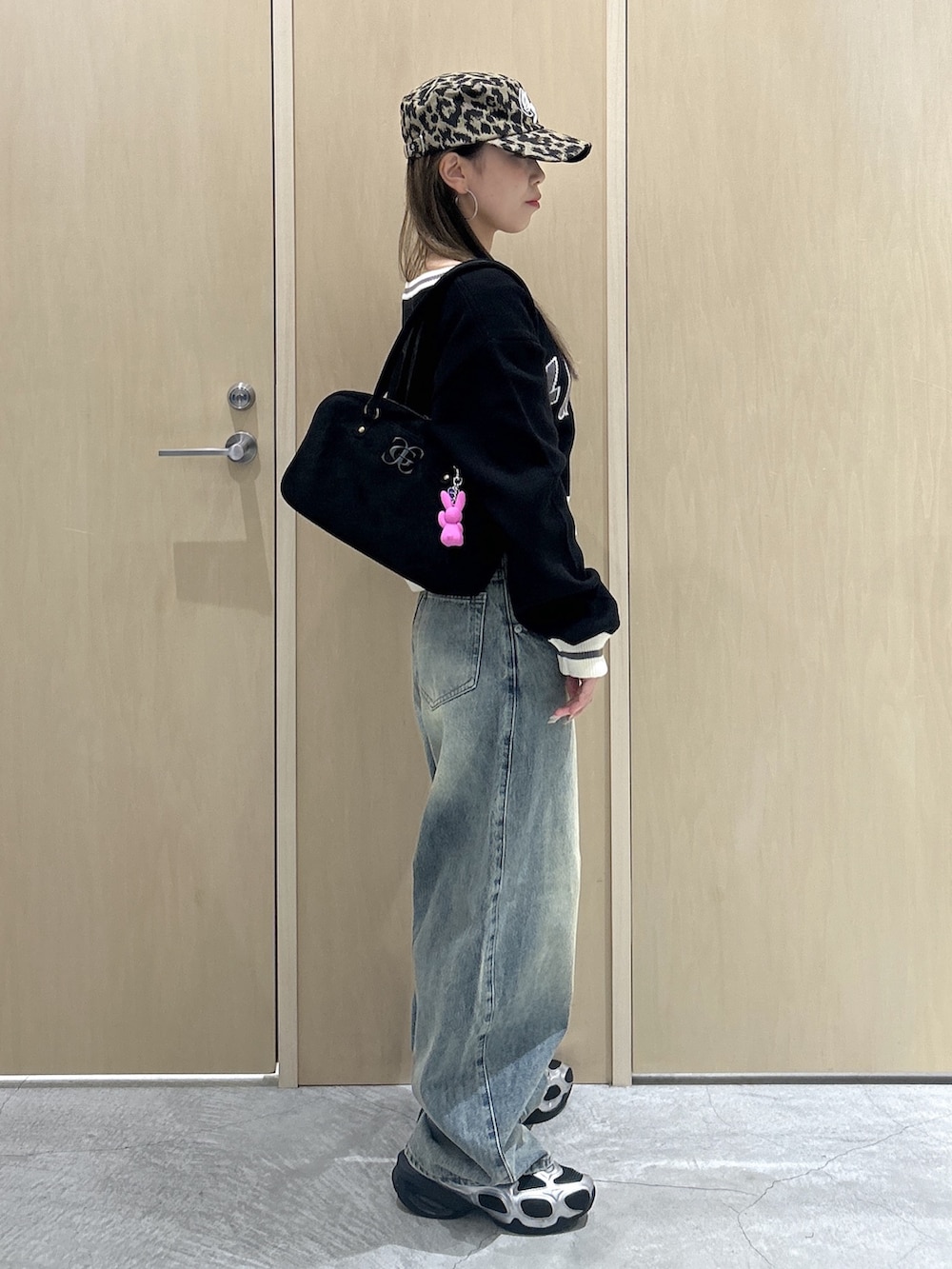 ブラック系のニット/セーター、ブルー系のデニムパンツ、ブラック系のハンドバッグを着用したレディースの秋コーディネートの2枚目の写真