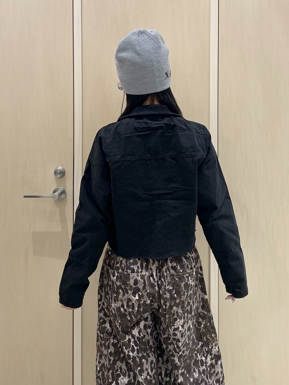 ブラック系のブルゾン、ベージュ系のカーゴパンツ、ブラック系のショルダーバッグを着用したレディースの冬コーディネートの5枚目の写真