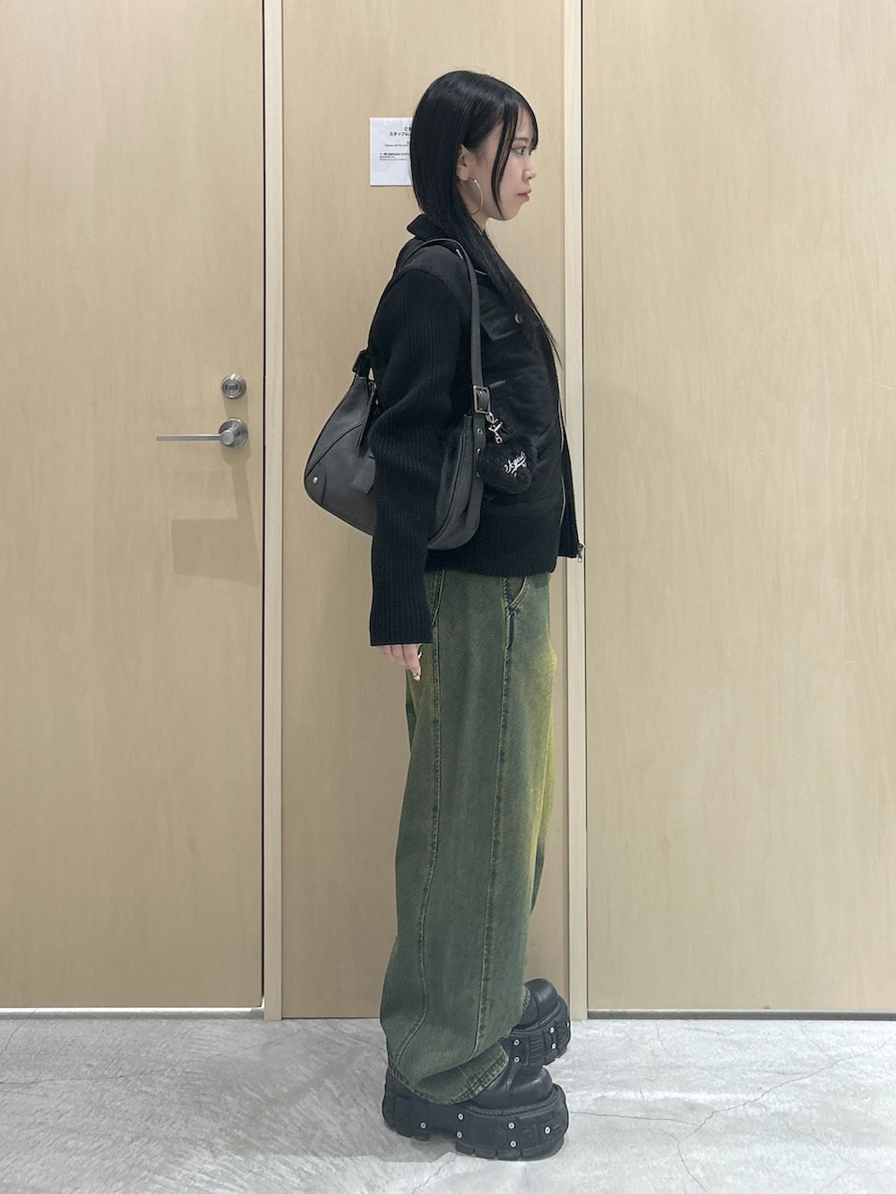 グレー系のTシャツ/カットソー、ブラック系のブルゾン、ブラック系のハンドバッグを着用したレディースの冬コーディネートの2枚目の写真