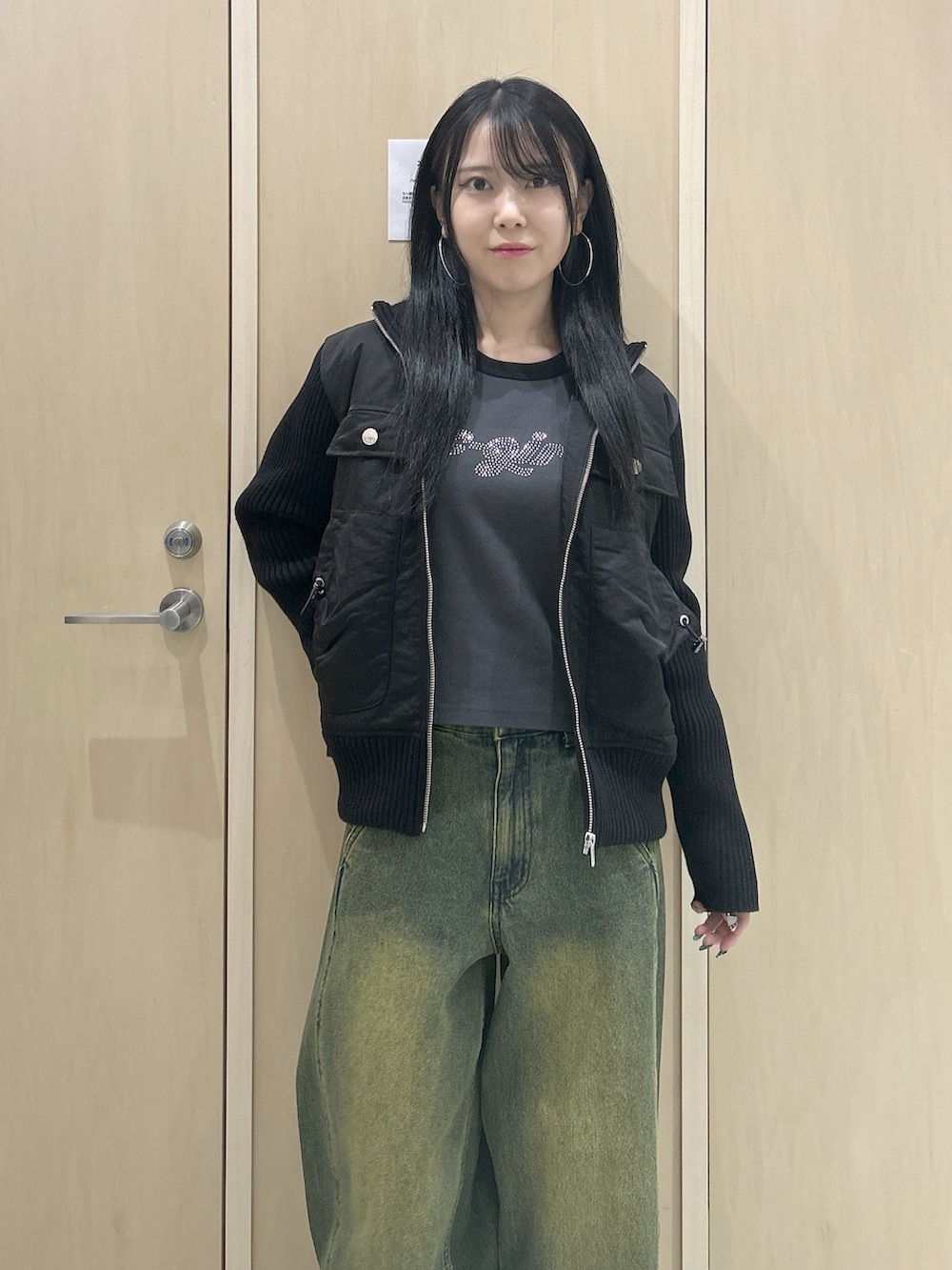 グレー系のTシャツ/カットソー、ブラック系のブルゾン、ブラック系のハンドバッグを着用したレディースの冬コーディネートの4枚目の写真