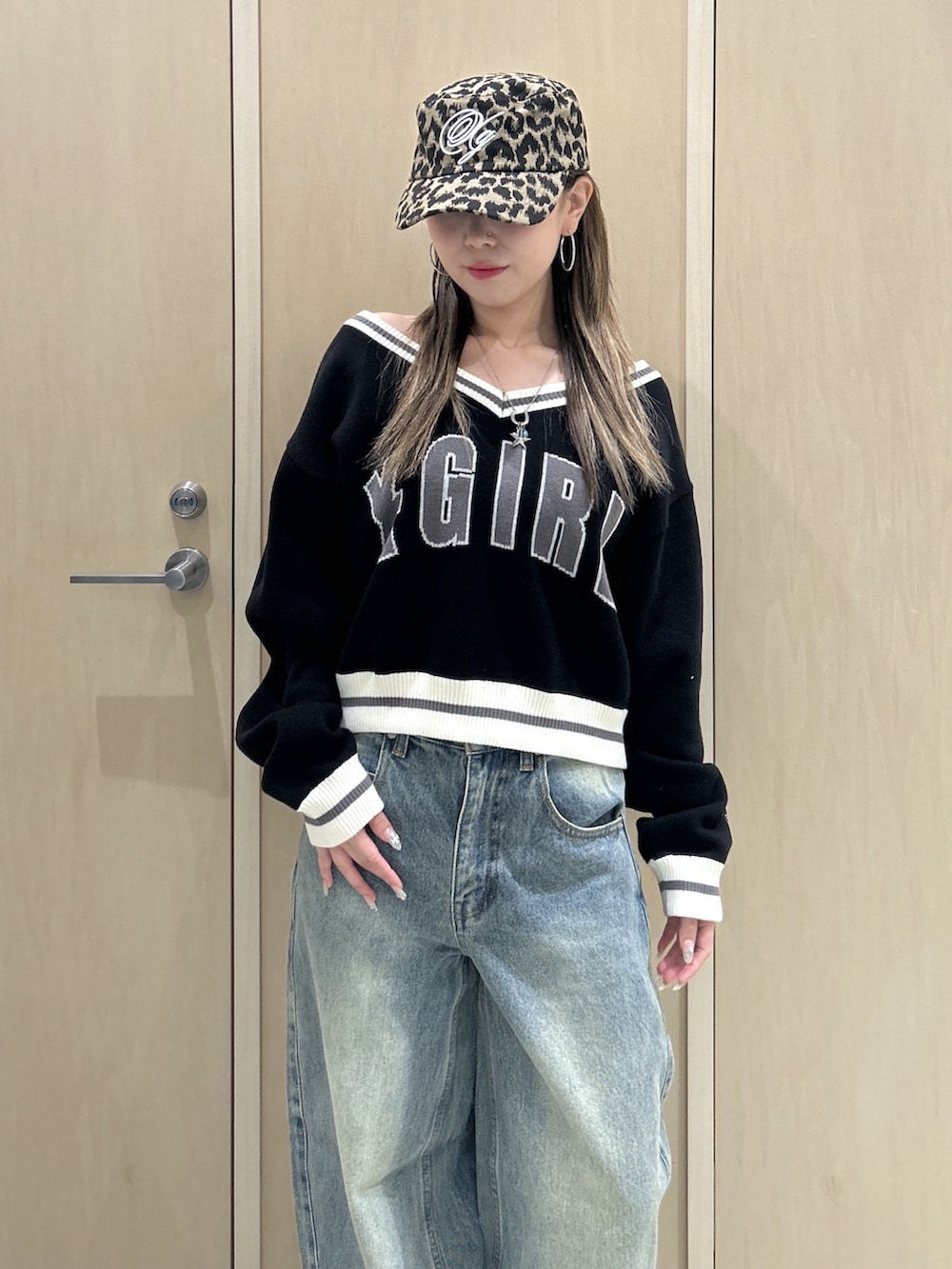ブラック系のニット/セーター、ブルー系のデニムパンツ、ブラック系のハンドバッグを着用したレディースの秋コーディネートの4枚目の写真