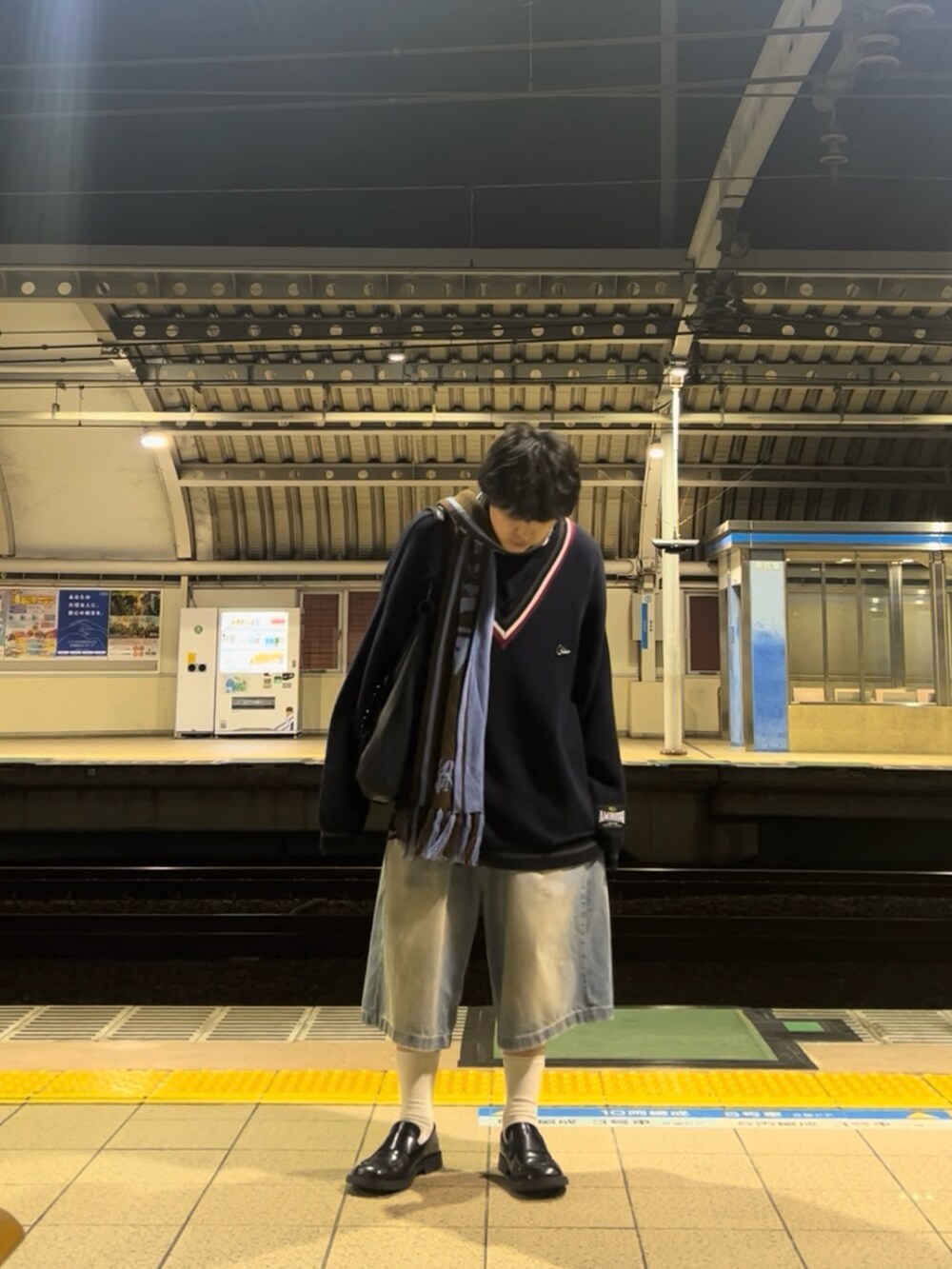 ブラック系のローファー、ブルー系のニット/セーター、ブルー系のデニムパンツを着用したメンズの冬コーディネートの2枚目の写真