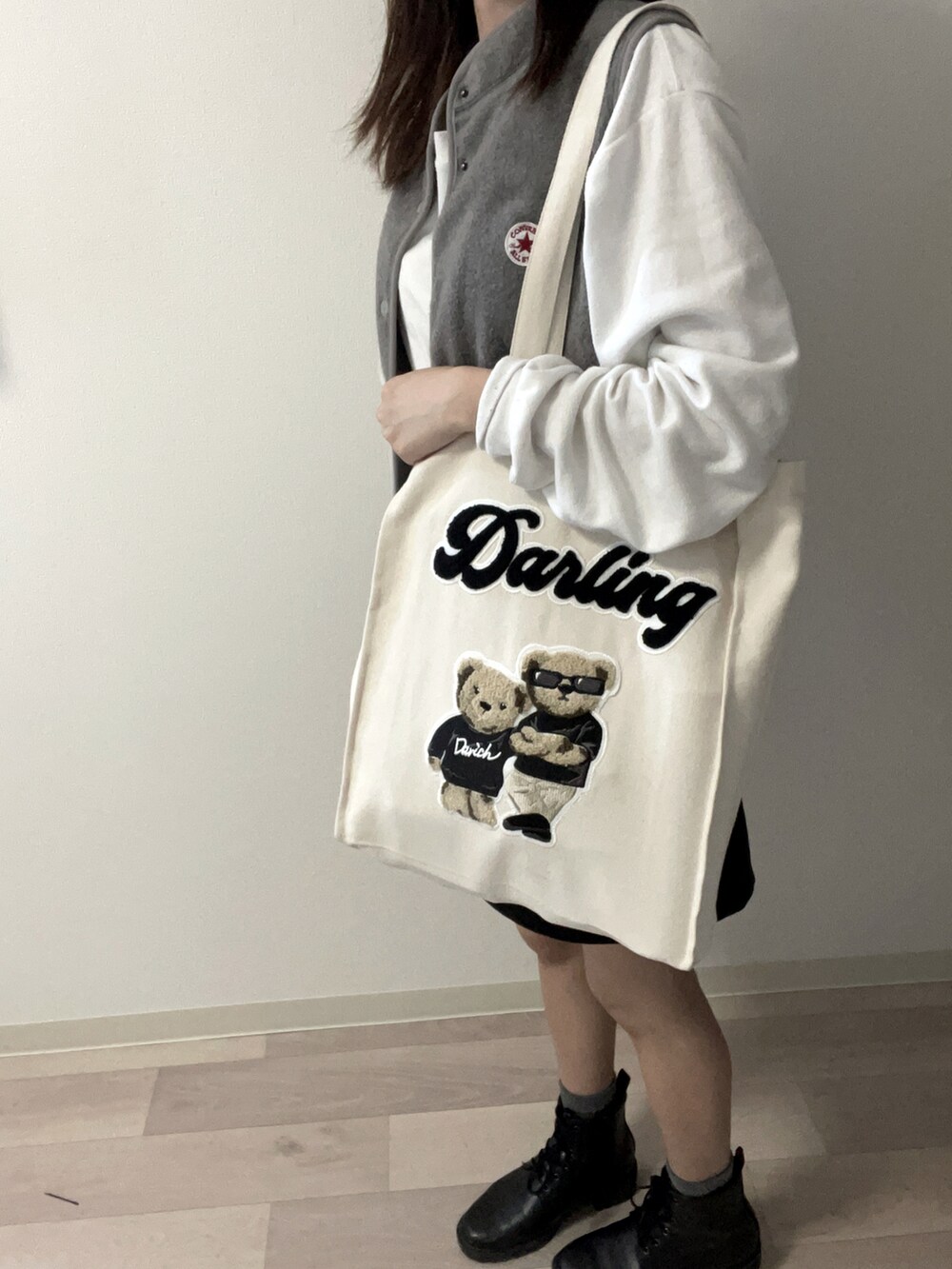 ブラック系のブーツ、ブラック系のスカート、ホワイト系のTシャツ/カットソーを着用したレディースの秋コーディネートの3枚目の写真