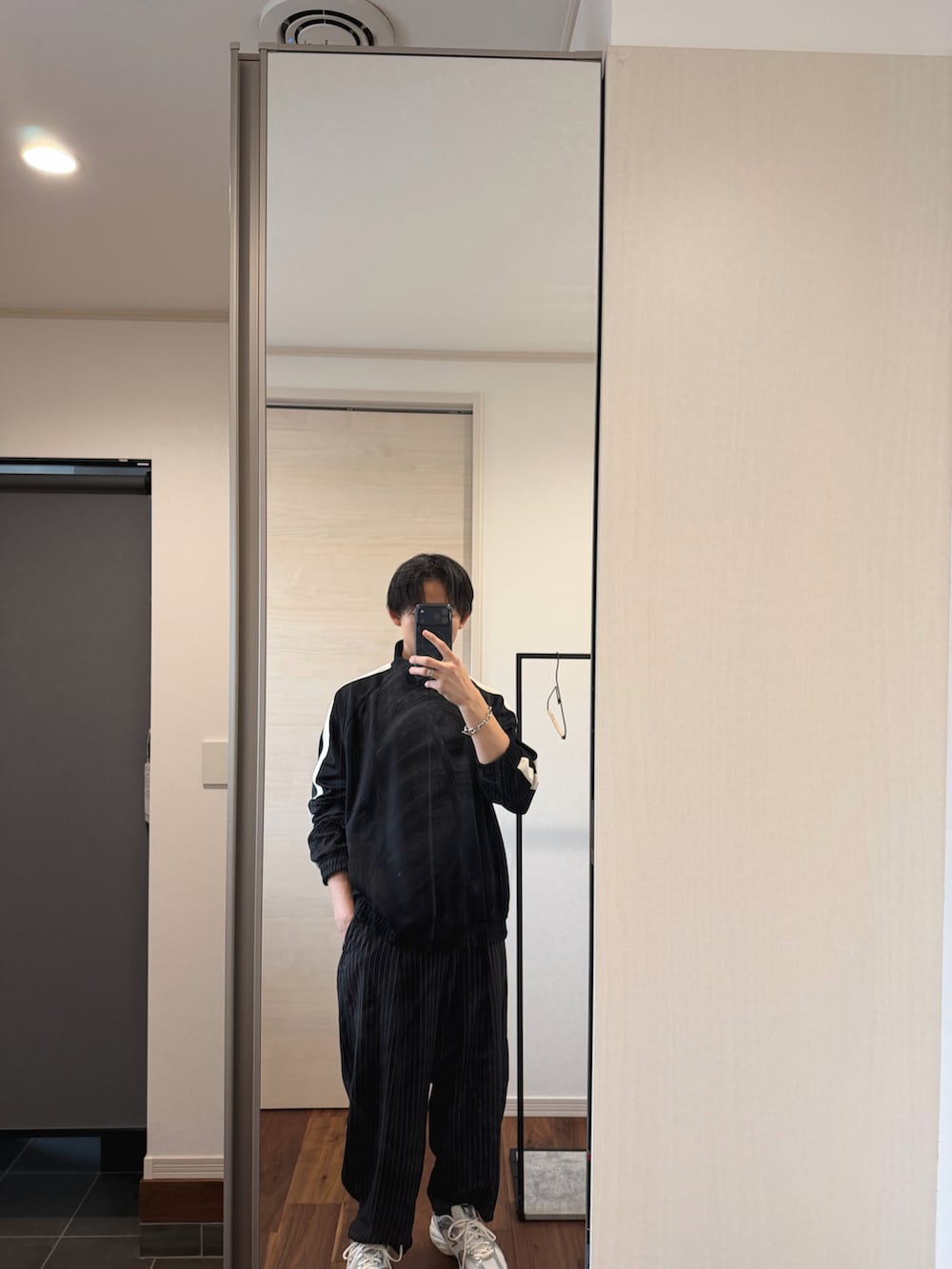 シルバー系のスニーカー、ブラック系のジャージを着用したメンズの春コーディネートの2枚目の写真