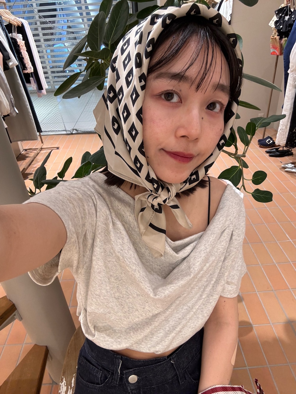 ブルー系のデニムパンツ、グレー系のTシャツ/カットソー、レッド系のトートバッグを着用したレディースの春コーディネートの2枚目の写真