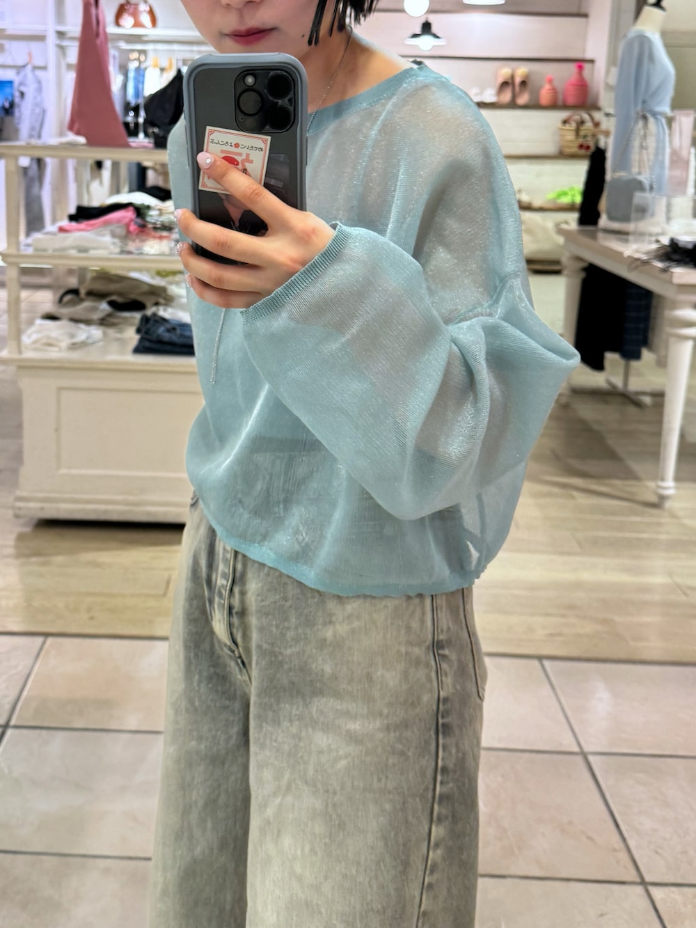 ベージュ系のデニムパンツ、グリーン系のニット/セーターを着用したレディースの春コーディネートの2枚目の写真