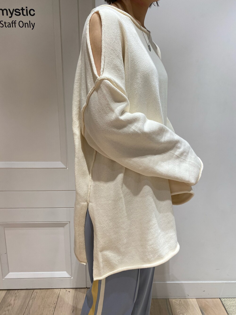 ブルー系のスウェットパンツ、シルバー系のサンダル、ホワイト系のニット/セーターを着用したレディースの冬コーディネートの2枚目の写真