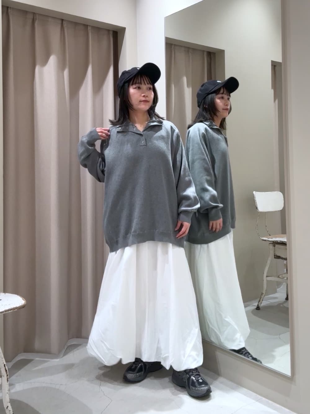 グレー系のニット/セーター、ホワイト系のスカート、ホワイト系のTシャツ/カットソーを着用したレディースの冬コーディネートの2枚目の写真