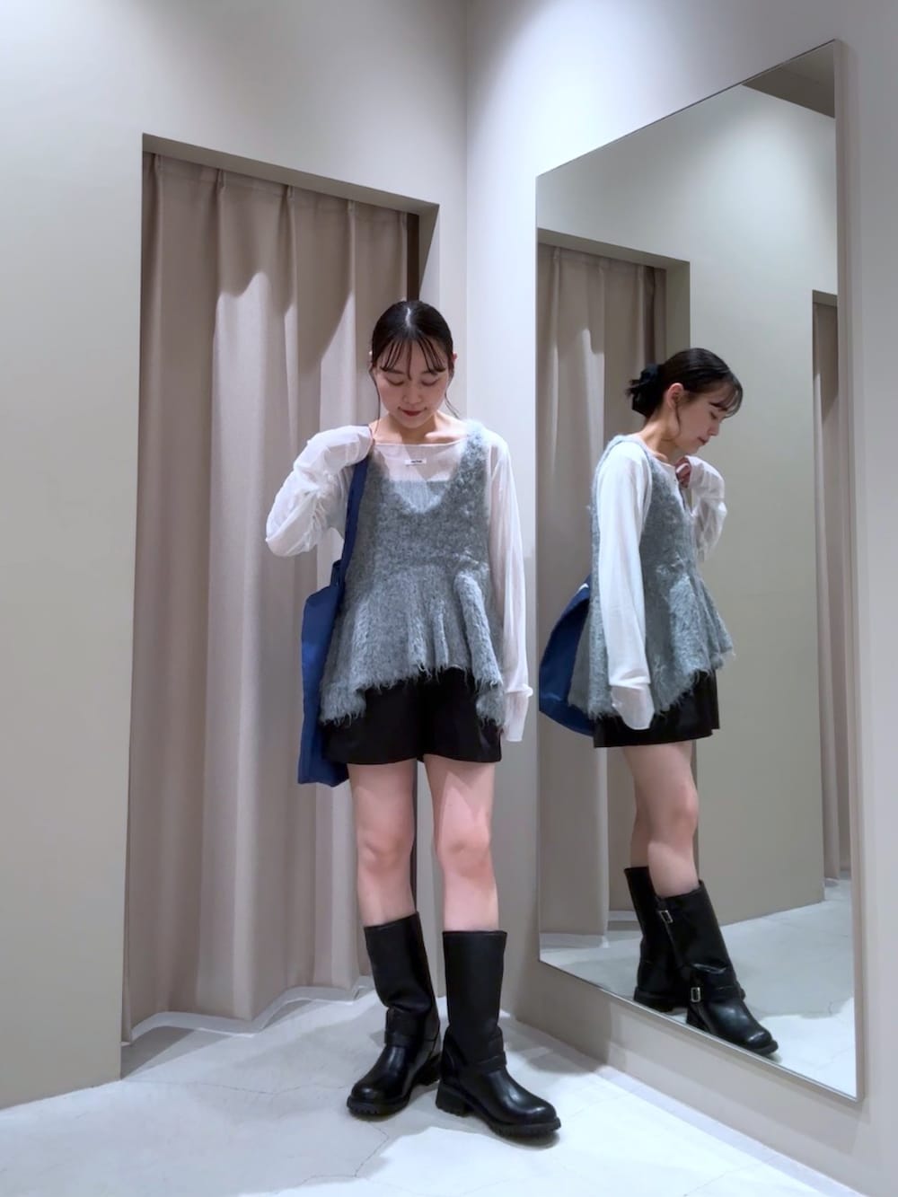 グレー系のベスト、ホワイト系のTシャツ/カットソー、ブルー系のトートバッグを着用したレディースの秋コーディネートの2枚目の写真