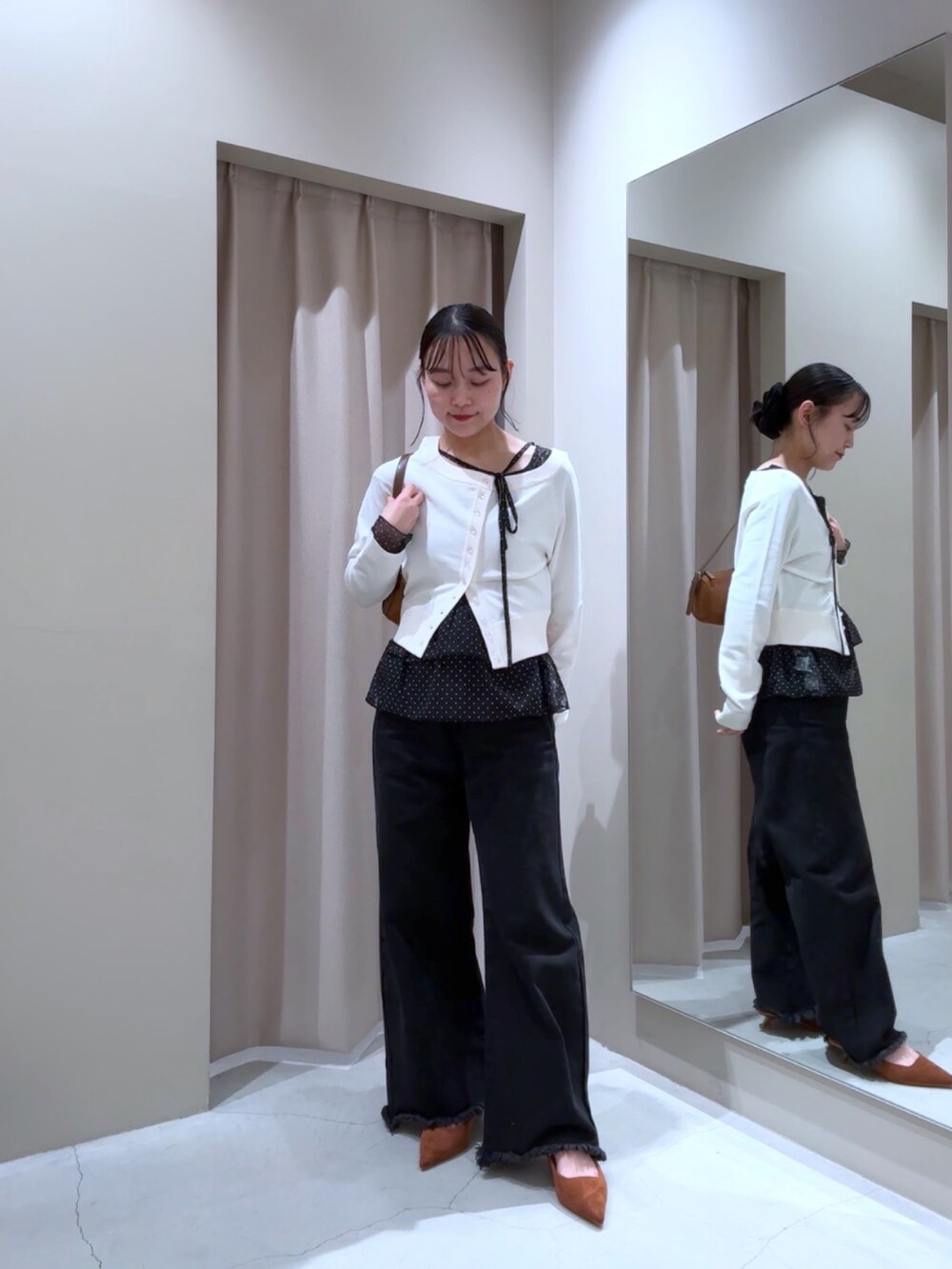 ブラック系のTシャツ/カットソー、ホワイト系のカーディガン/ボレロ、ブラック系のデニムパンツを着用したレディースの秋コーディネートの2枚目の写真