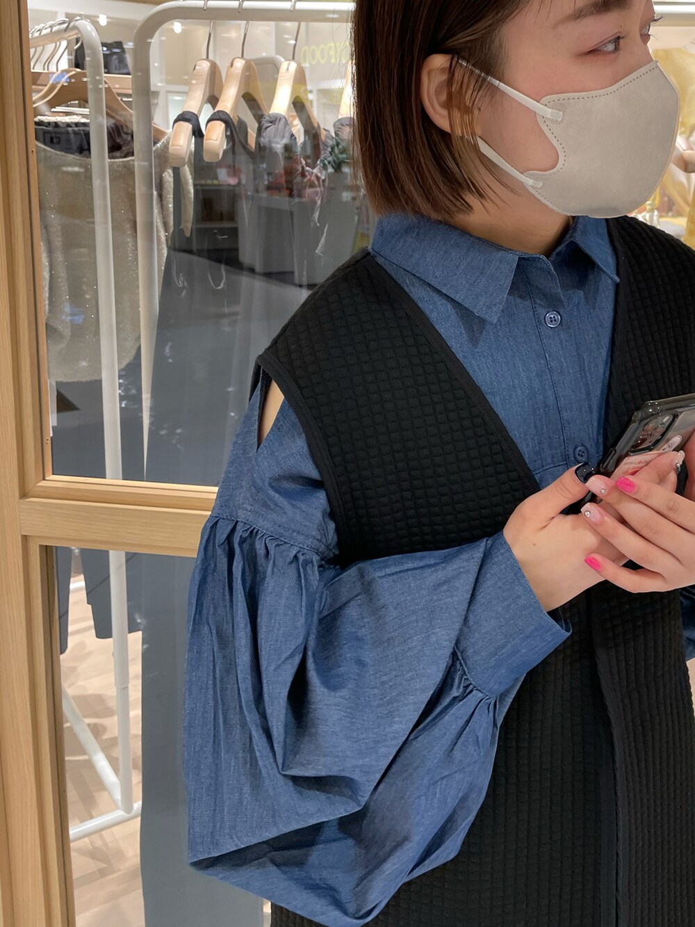 ブラック系のベスト、ブルー系のシャツ/ブラウス、ブラック系のサンダルを着用したレディースの夏コーディネートの2枚目の写真