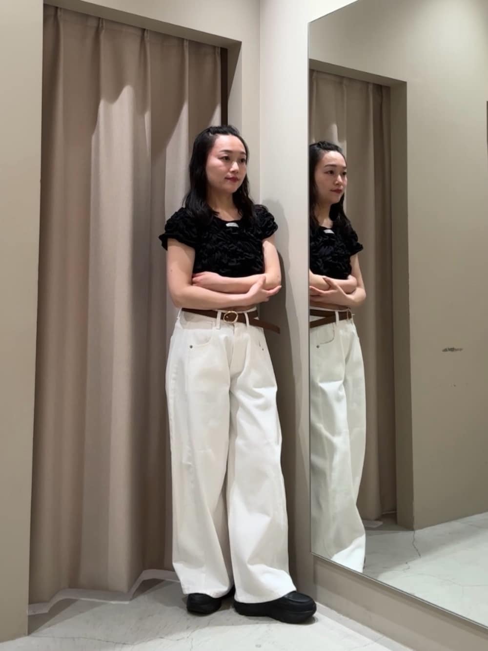 ホワイト系のデニムパンツ、ブラック系のTシャツ/カットソーを着用したレディースの春コーディネートの2枚目の写真