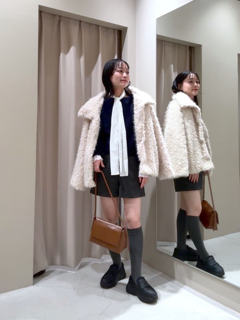 ブルー系のニット/セーター、ホワイト系のその他アウター、ホワイト系のTシャツ/カットソーを着用したレディースの冬コーディネートの2枚目の写真