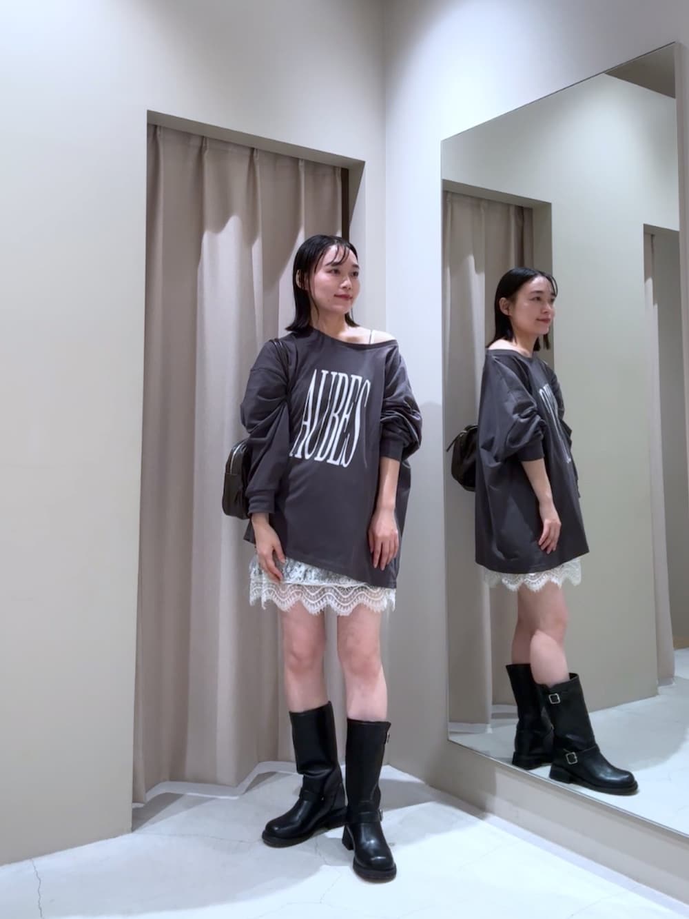 グレー系のTシャツ/カットソー、ホワイト系のシャツ/ブラウス、ブラック系のブーツを着用したレディースの秋コーディネートの2枚目の写真