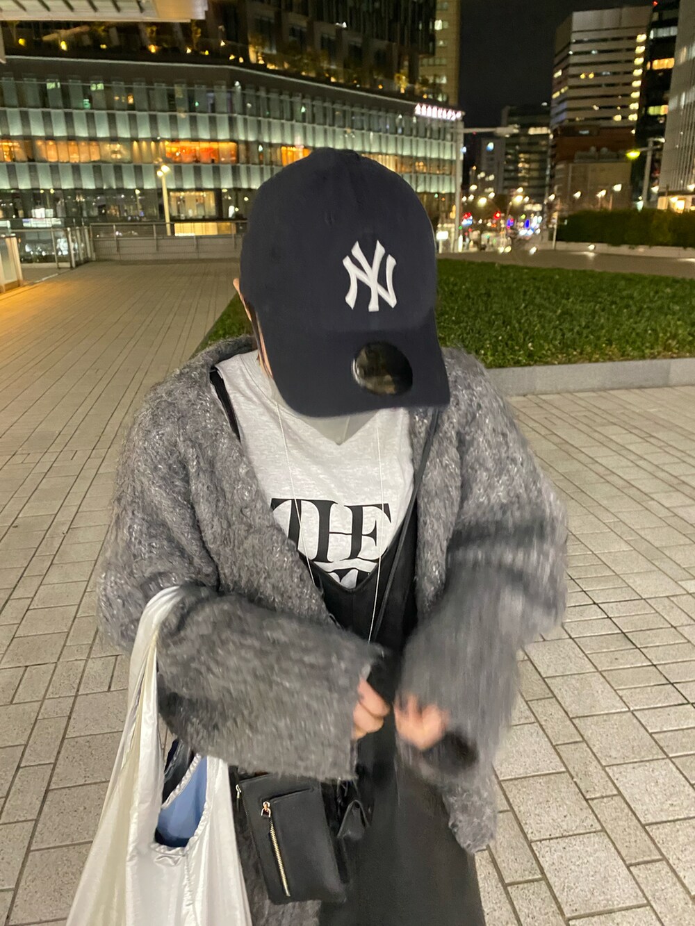 ブラック系のワンピース、シルバー系のエコバッグ/サブバッグ、グレー系のTシャツ/カットソーを着用したレディースの春コーディネートの2枚目の写真