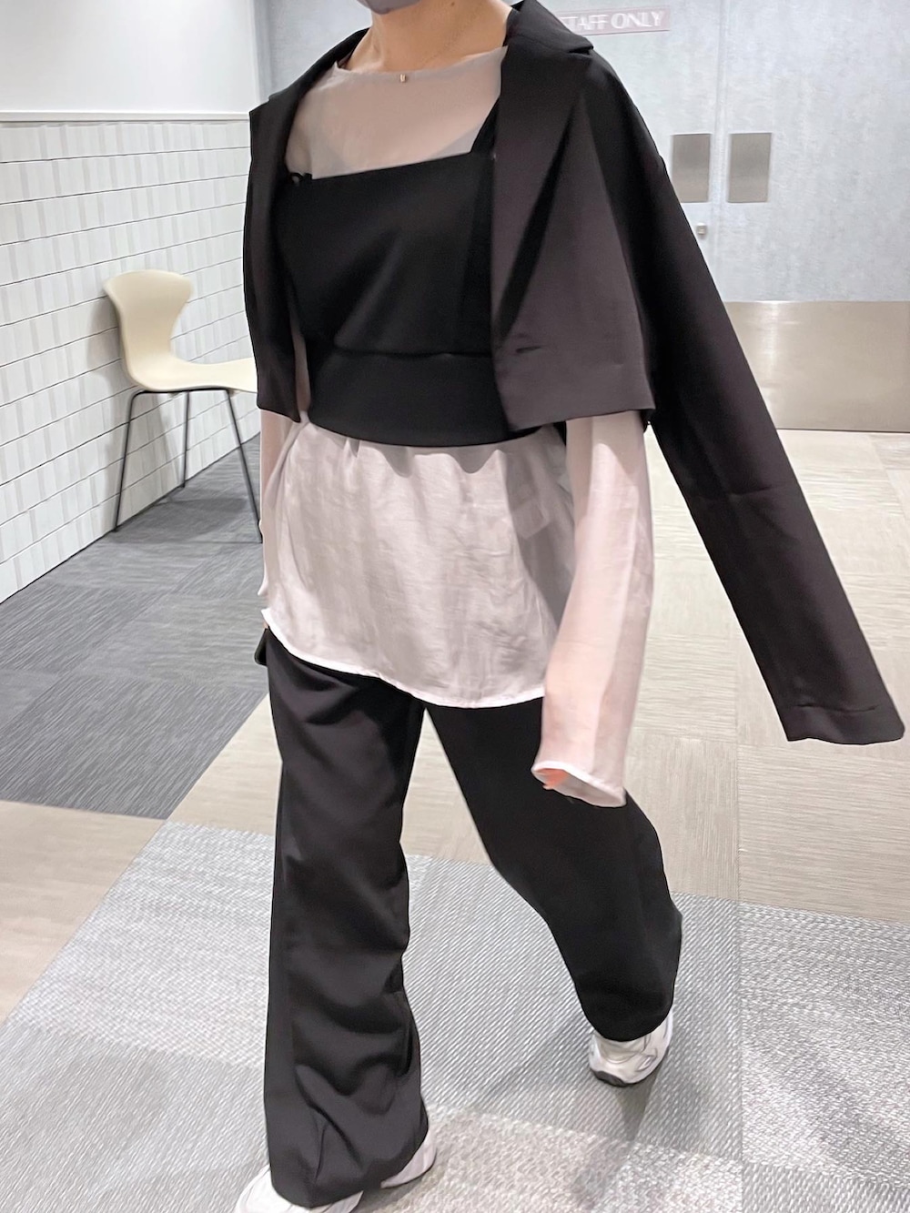 ブラック系のスラックス、ブラック系のベスト、グレー系のTシャツ/カットソーを着用したレディースの春コーディネートの2枚目の写真