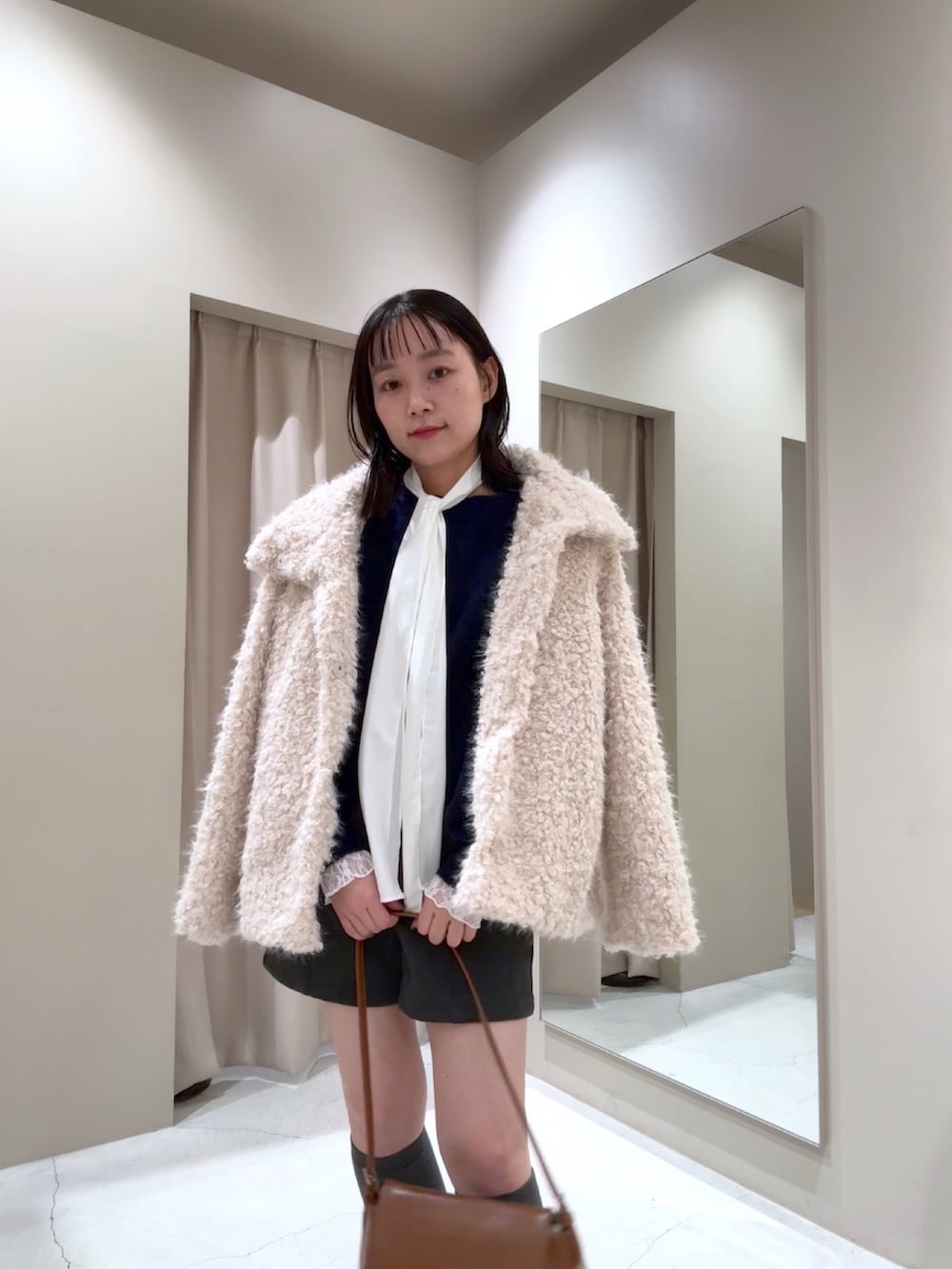 ブルー系のニット/セーター、ホワイト系のその他アウター、ホワイト系のTシャツ/カットソーを着用したレディースの冬コーディネートの3枚目の写真