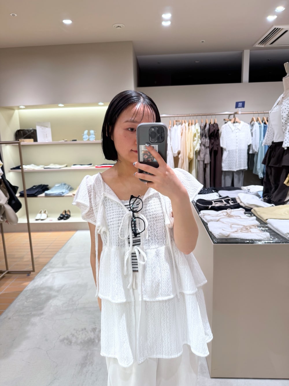 ホワイト系のチュニック、ホワイト系のキャミソール、ホワイト系のスウェットパンツを着用したレディースの夏コーディネートの2枚目の写真