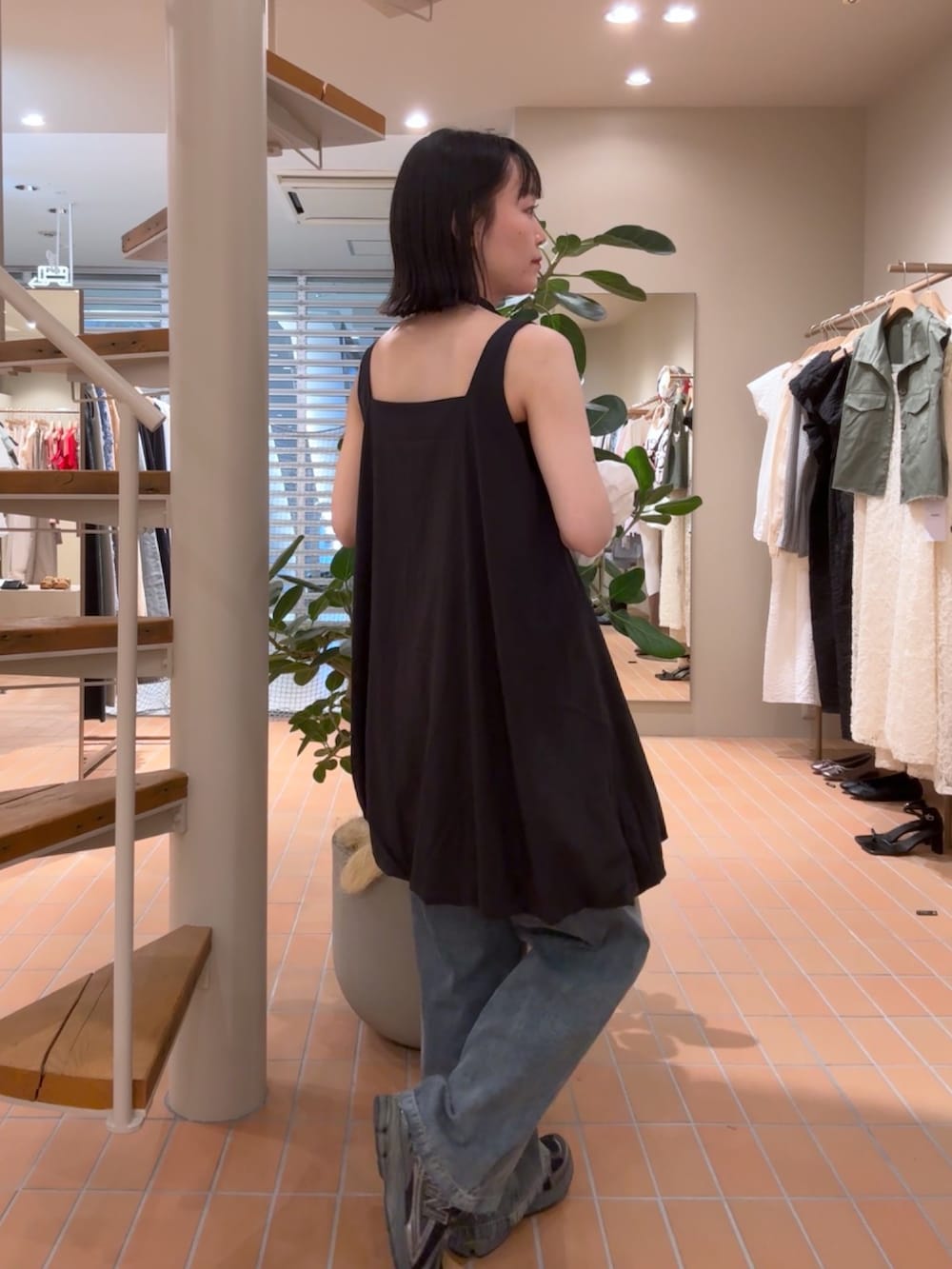 ブラック系のワンピース、ブルー系のデニムパンツ、ホワイト系のシュシュを着用したレディースの夏コーディネートの2枚目の写真