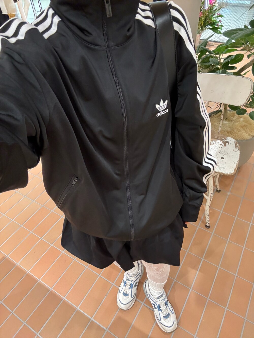 ブラック系のトートバッグを着用したレディースの春コーディネートの2枚目の写真