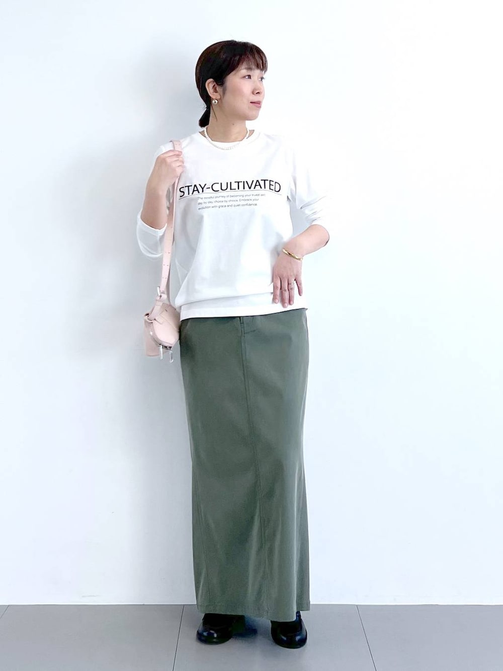 ホワイト系のTシャツ/カットソー、グリーン系のスカート、ピンク系のショルダーバッグを着用したレディースの冬コーディネートの8枚目の写真