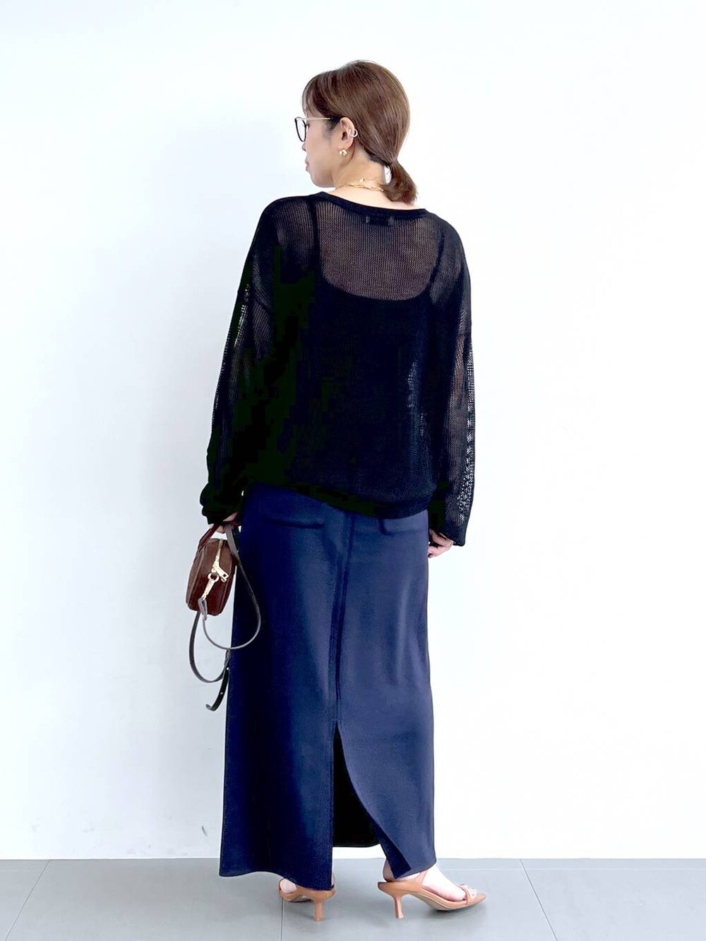 ブラウン系のサンダル、ブラック系のニット/セーター、ブルー系のスカートを着用したレディースの夏コーディネートの7枚目の写真