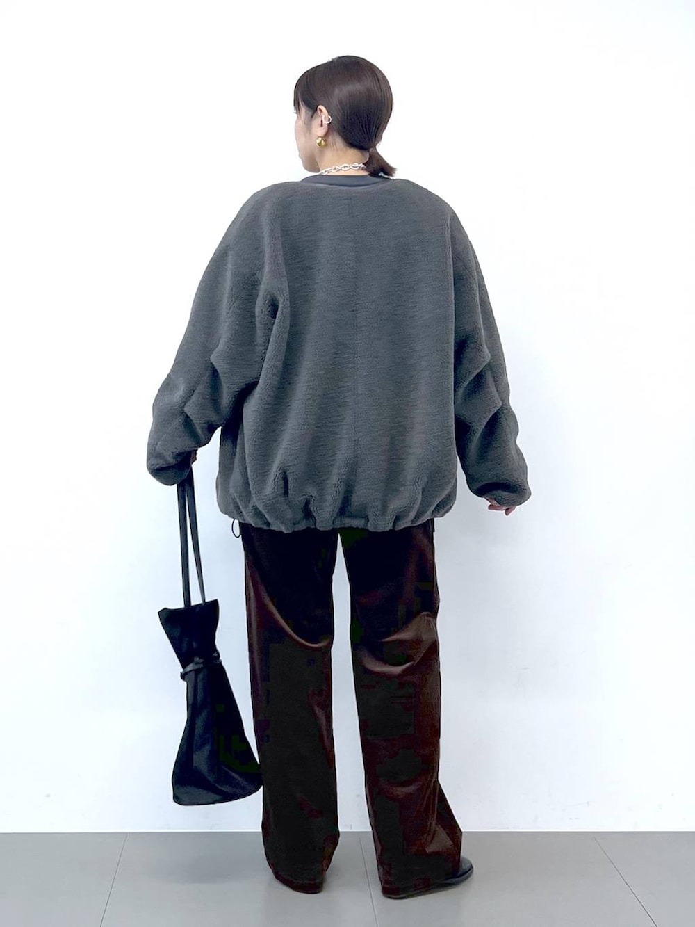 ブラック系のブーツ、グレー系のブルゾン、シルバー系のネックレスを着用したレディースの秋コーディネートの7枚目の写真