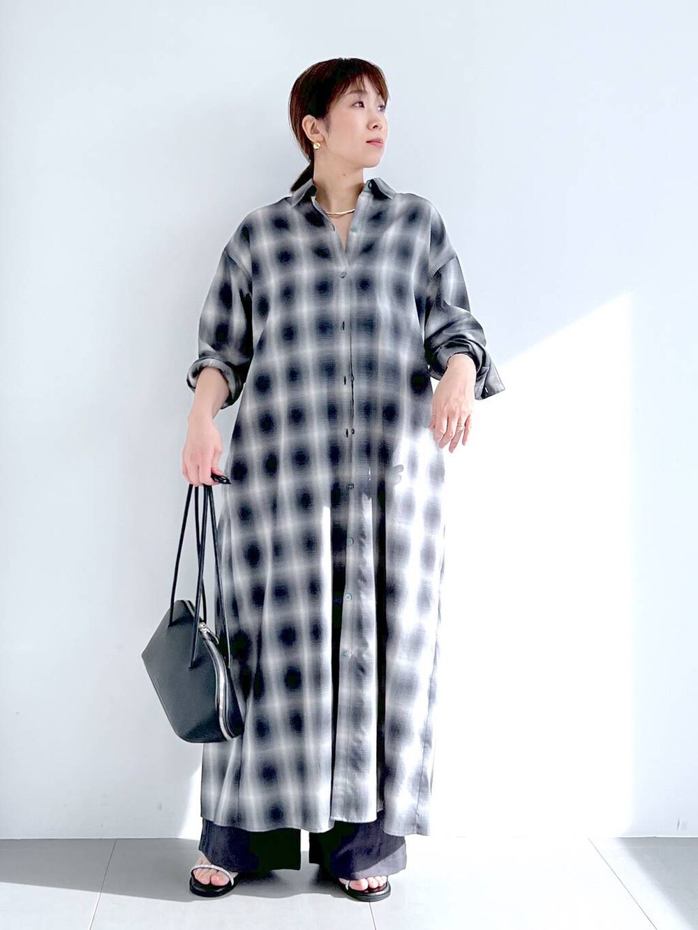 ブラック系のトートバッグ、グレー系のシャツワンピース、グレー系のその他パンツを着用したレディースの春コーディネートの4枚目の写真