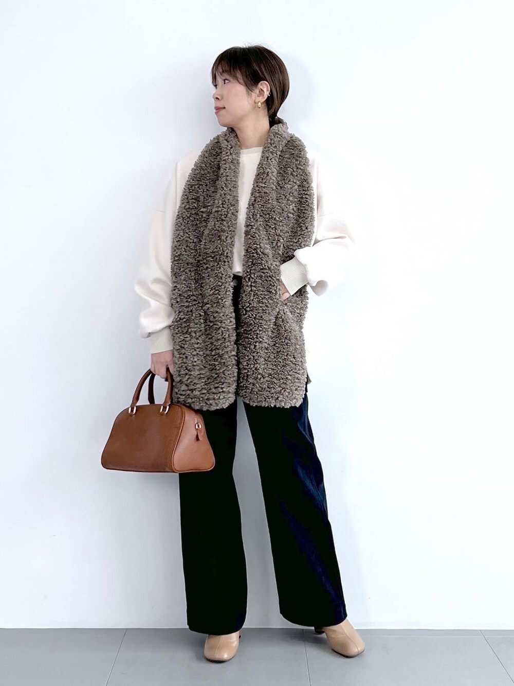 ブルー系のその他パンツ、イエロー系のボストンバッグ、ベージュ系のブーツを着用したレディースの秋コーディネートの5枚目の写真