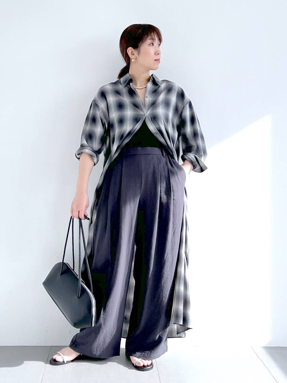 ブラック系のトートバッグ、グレー系のシャツワンピース、グレー系のその他パンツを着用したレディースの春コーディネートの6枚目の写真