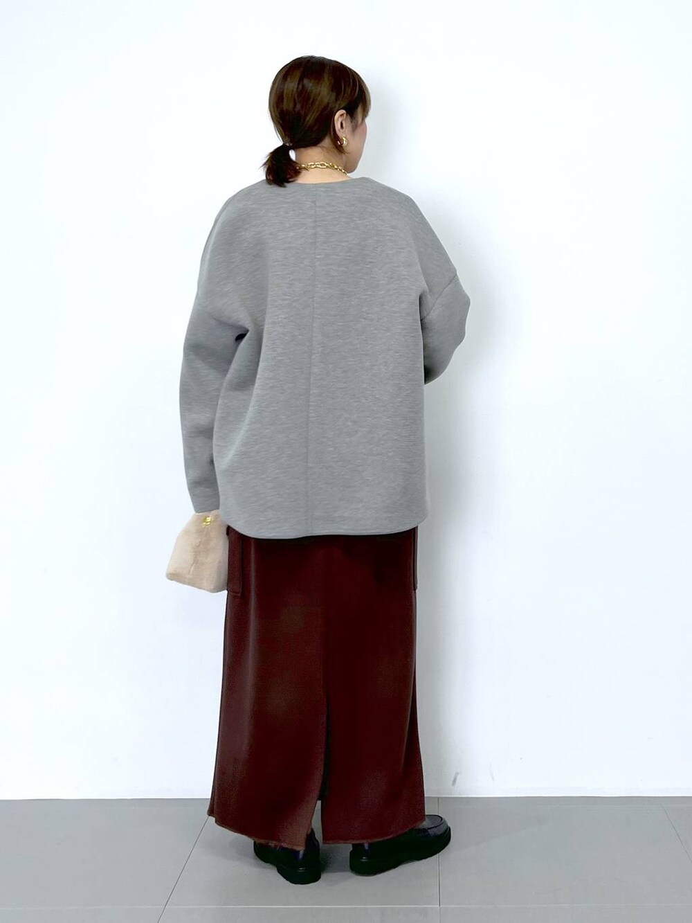 ブラウン系のスカート、ホワイト系のショルダーバッグ、ホワイト系のTシャツ/カットソーを着用したレディースの秋コーディネートの8枚目の写真