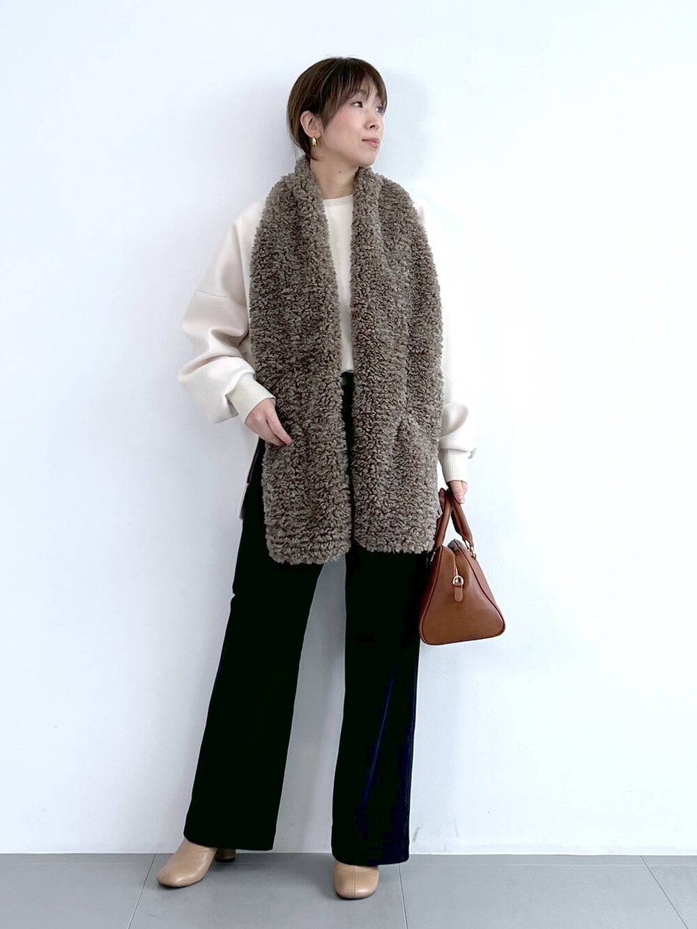 ブルー系のその他パンツ、イエロー系のボストンバッグ、ベージュ系のブーツを着用したレディースの秋コーディネートの3枚目の写真