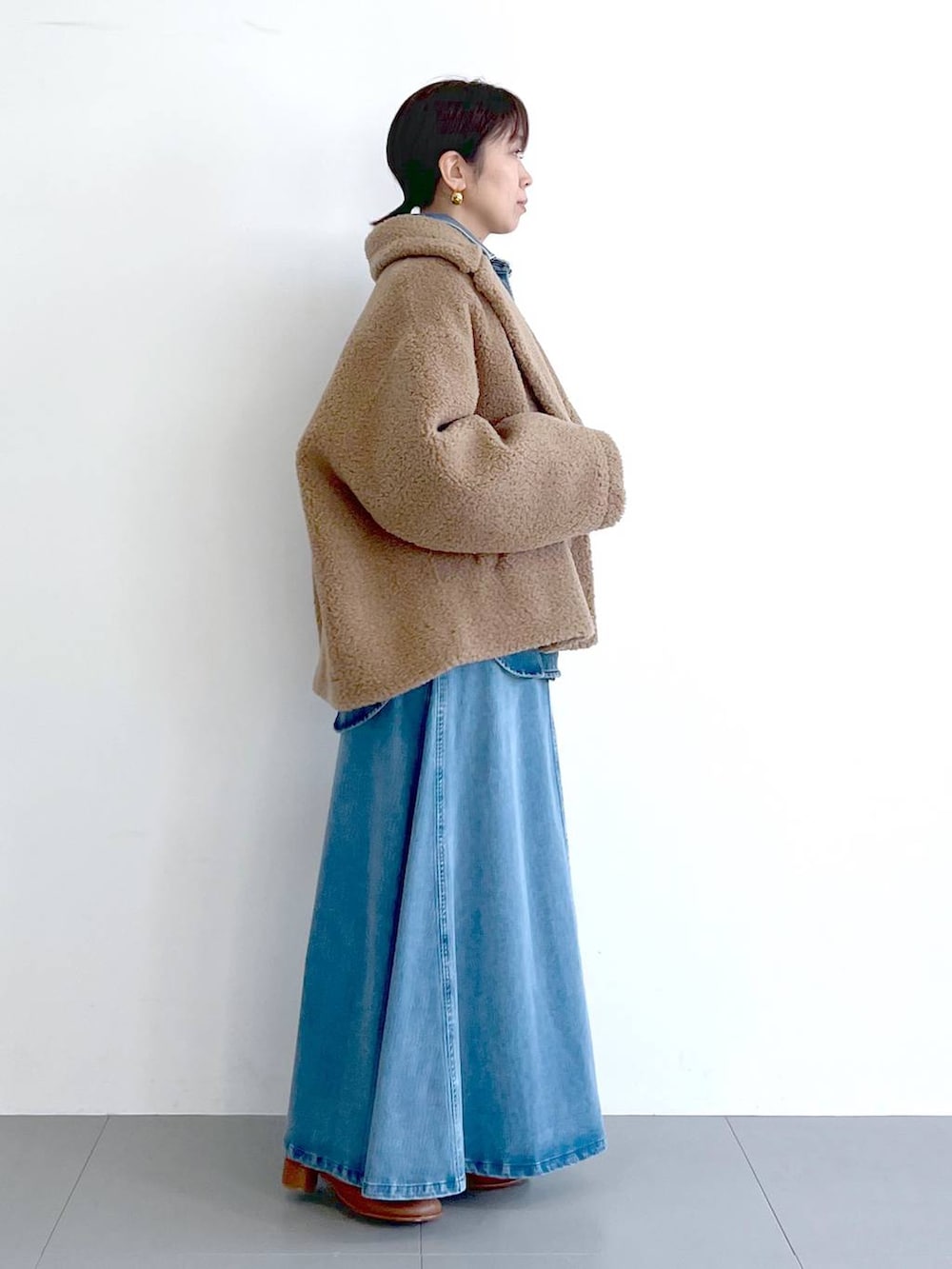 イエロー系のピーコート、ブルー系のシャツ/ブラウス、ブラウン系のショルダーバッグを着用したレディースの秋コーディネートの6枚目の写真