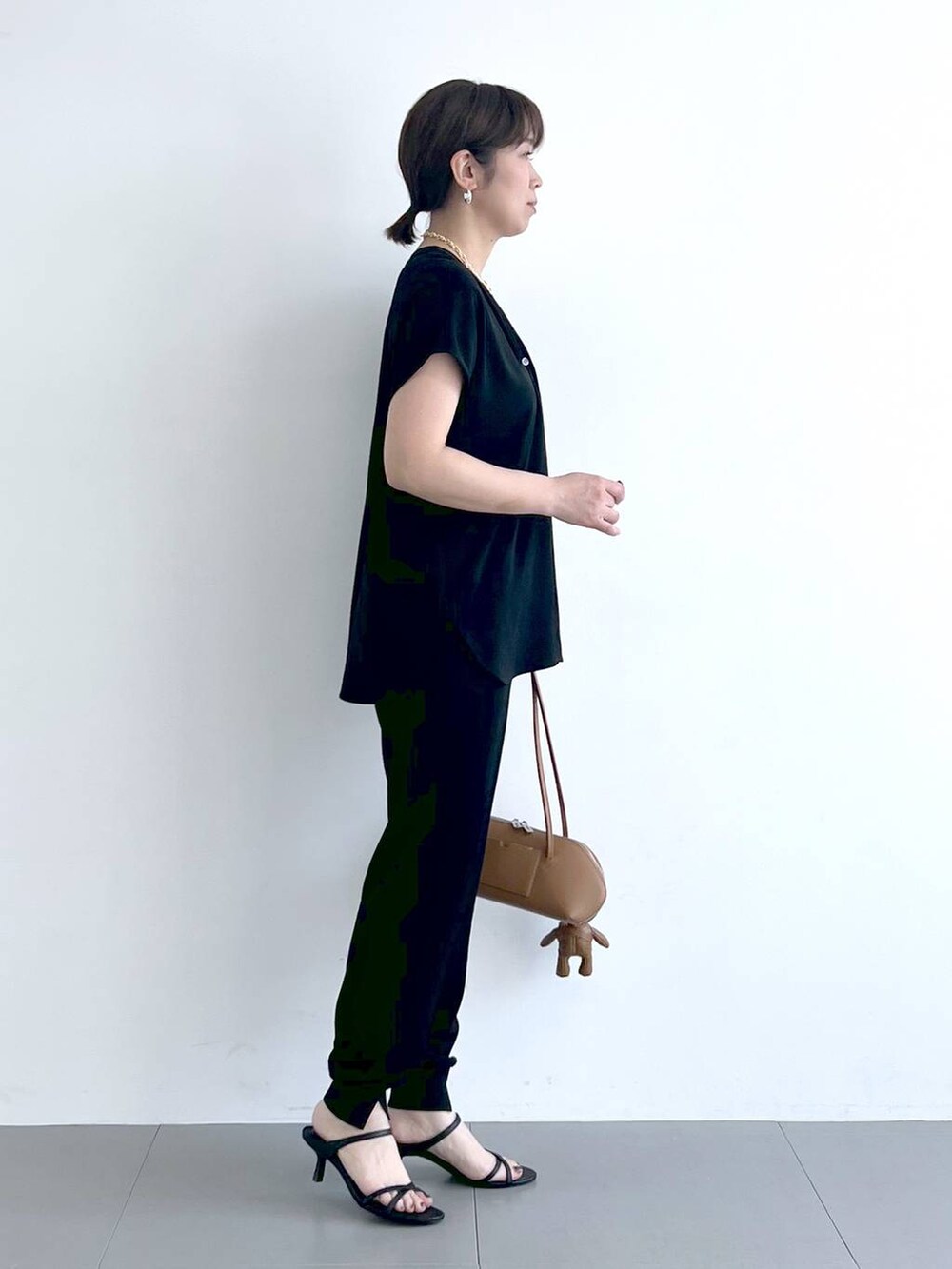 ブラウン系のハンドバッグ、ブラック系のシャツ/ブラウス、ブラック系のサンダルを着用したレディースの春コーディネートの7枚目の写真