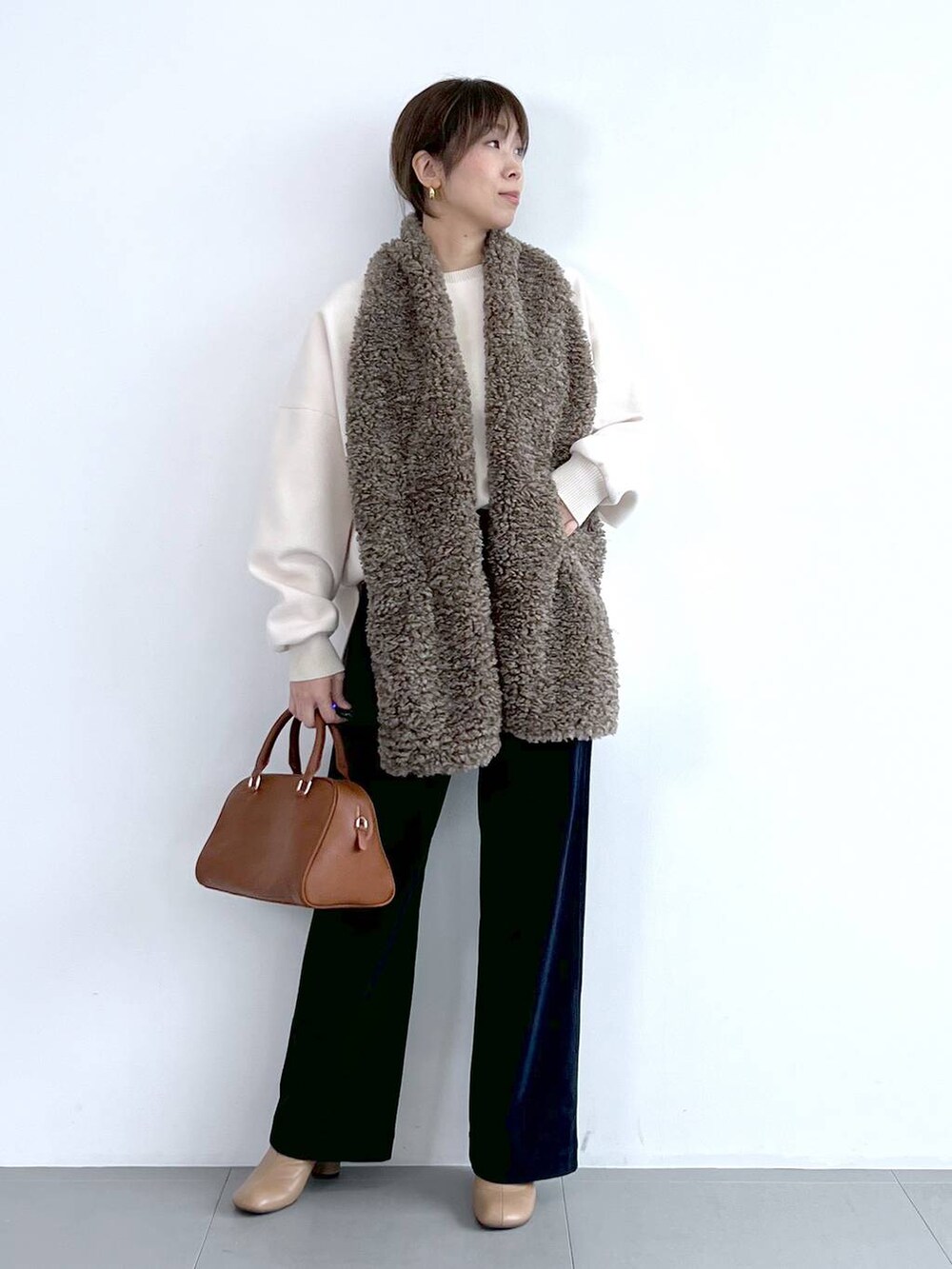 ブルー系のその他パンツ、イエロー系のボストンバッグ、ベージュ系のブーツを着用したレディースの秋コーディネートの2枚目の写真