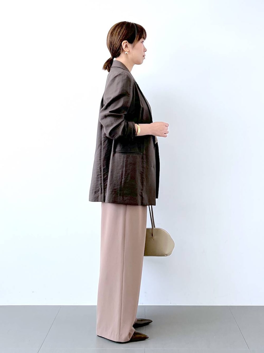 ベージュ系のトートバッグ、イエロー系のその他パンツ、ブラウン系のパンプスを着用したレディースの夏コーディネートの9枚目の写真