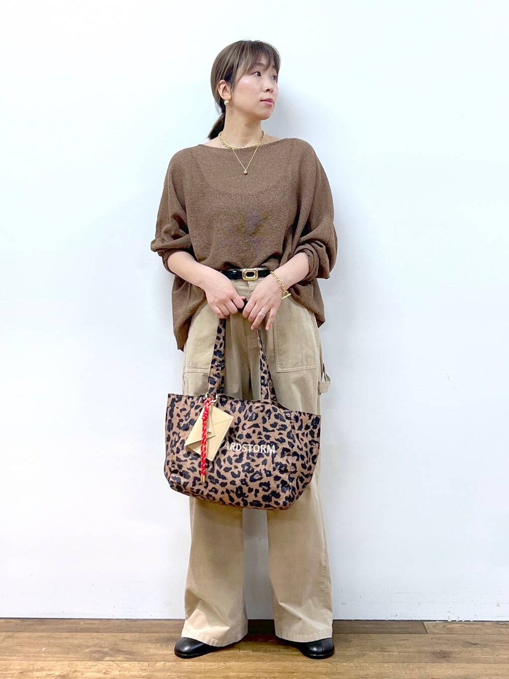 ブラウン系のニット/セーター、ブラウン系のトートバッグ、その他のピアス（両耳用）を着用したレディースの夏コーディネートの7枚目の写真