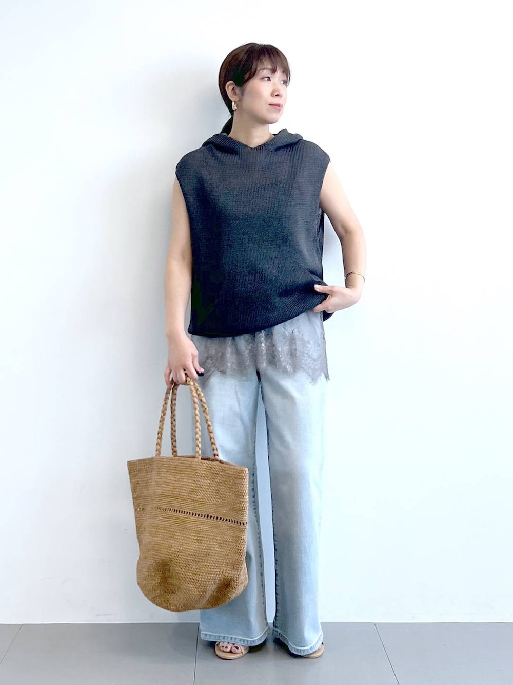 ブルー系のデニムパンツ、グレー系のキャミソール、グレー系のニット/セーターを着用したレディースの春コーディネートの4枚目の写真