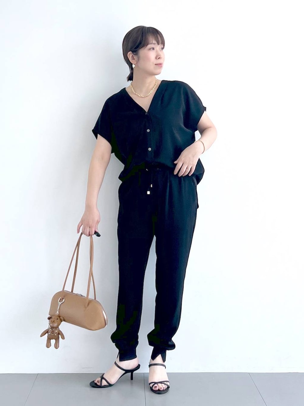 ブラウン系のハンドバッグ、ブラック系のシャツ/ブラウス、ブラック系のサンダルを着用したレディースの春コーディネートの3枚目の写真