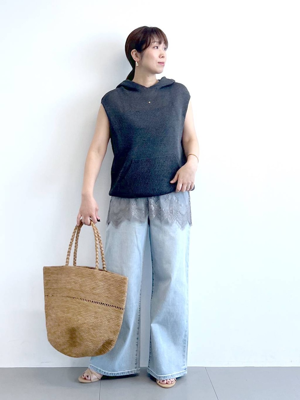 ブルー系のデニムパンツ、グレー系のキャミソール、グレー系のニット/セーターを着用したレディースの春コーディネートの2枚目の写真