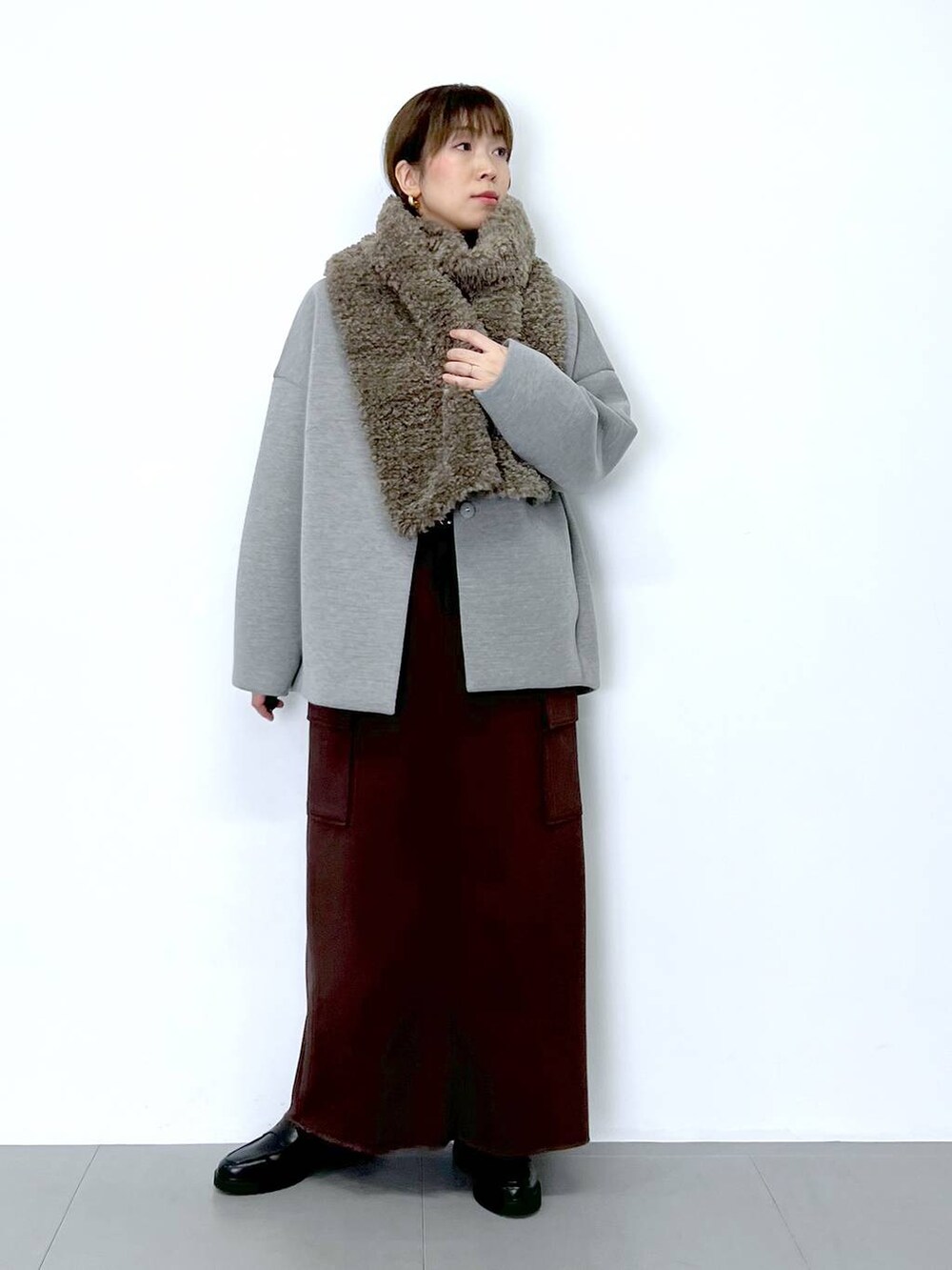 ブラウン系のスカート、ホワイト系のショルダーバッグ、ホワイト系のTシャツ/カットソーを着用したレディースの秋コーディネートの3枚目の写真