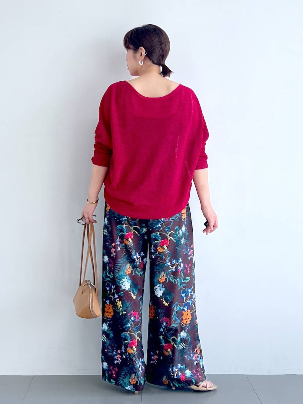 ブラウン系のその他パンツ、ブラウン系のハンドバッグ、レッド系のニット/セーターを着用したレディースの春コーディネートの3枚目の写真