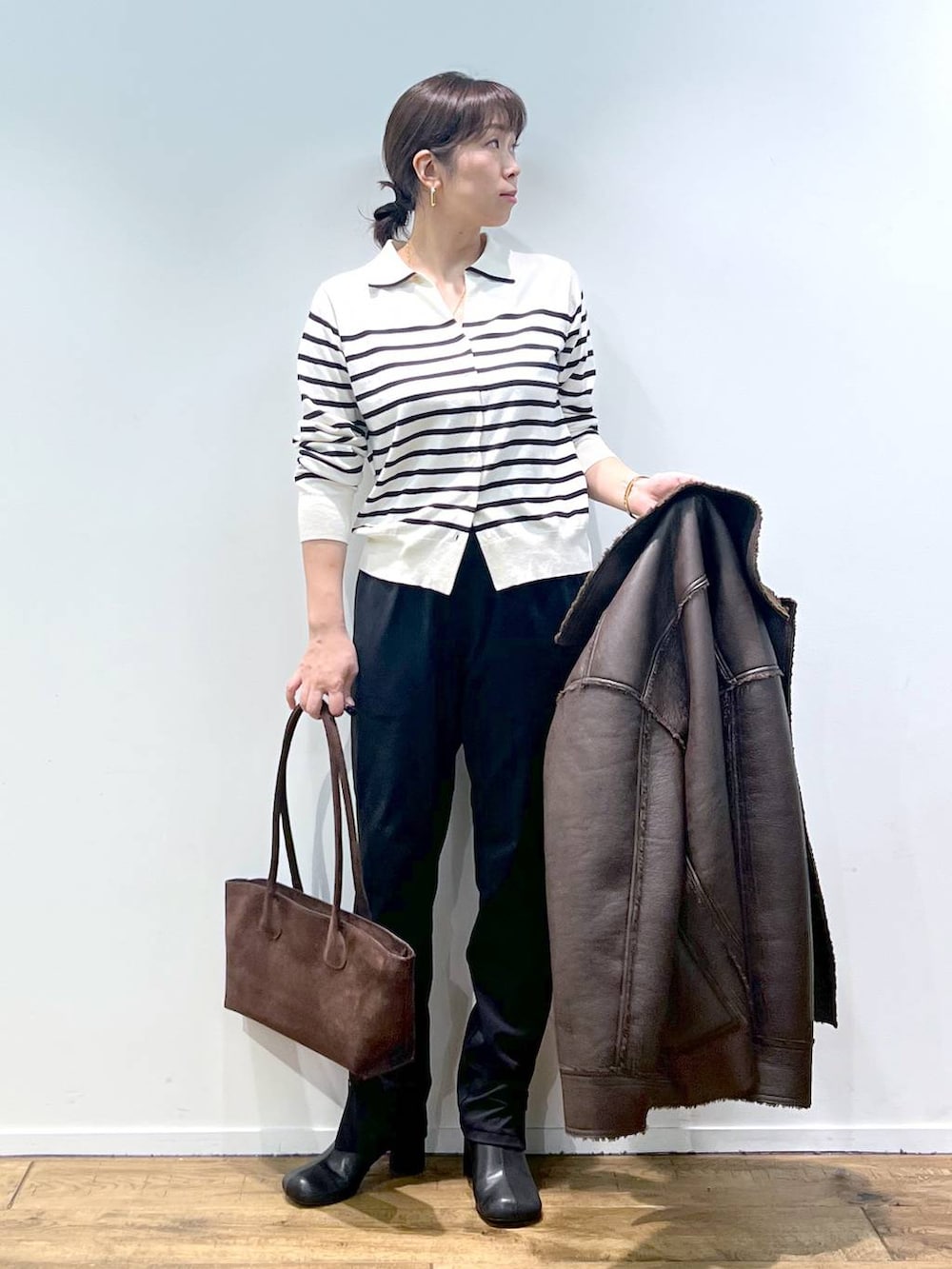 ブラック系のその他パンツ、ホワイト系のニット/セーター、その他のピアス(両耳用)を着用したレディースの秋コーディネートの5枚目の写真